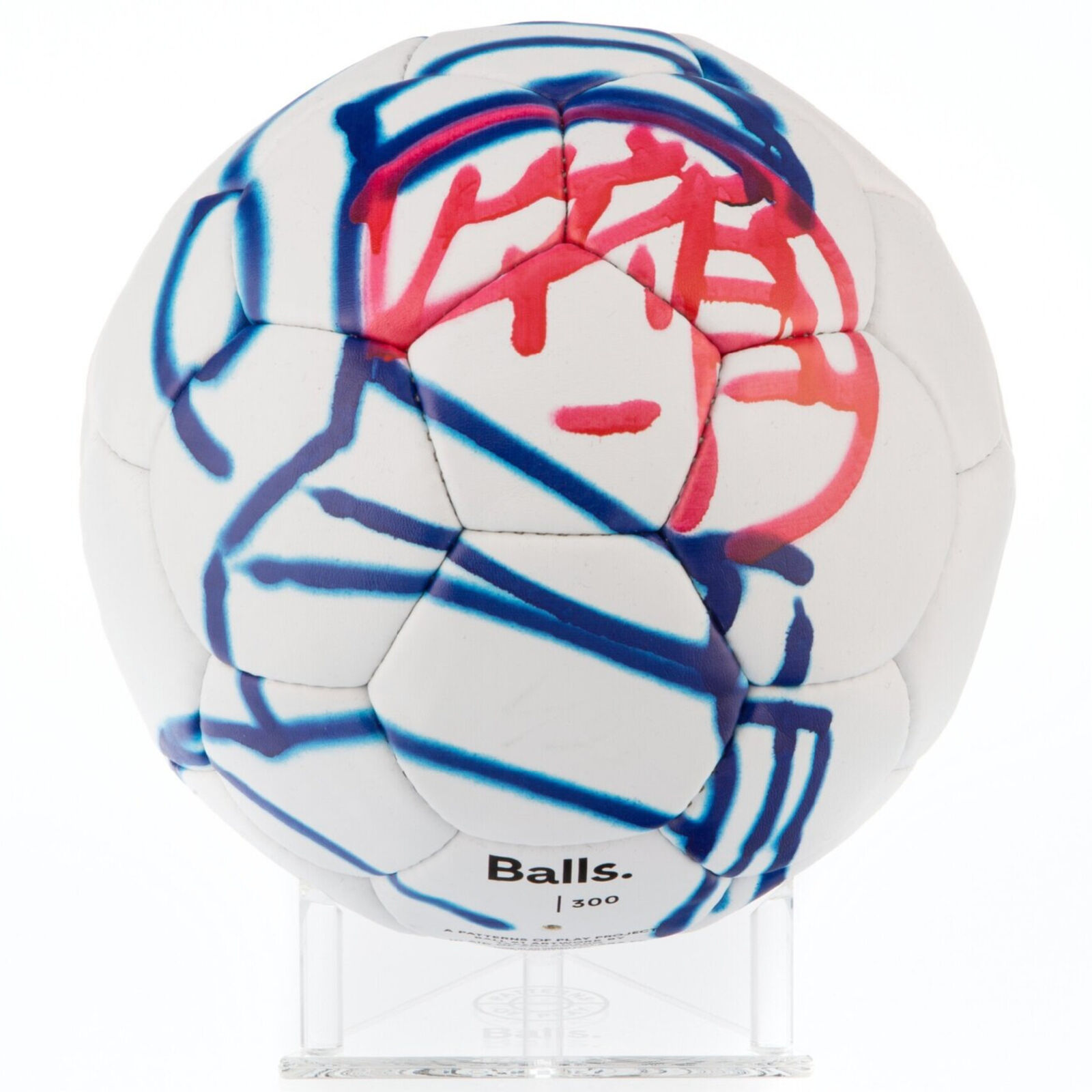 A white soccer ball with blue and red paint splatters on it.