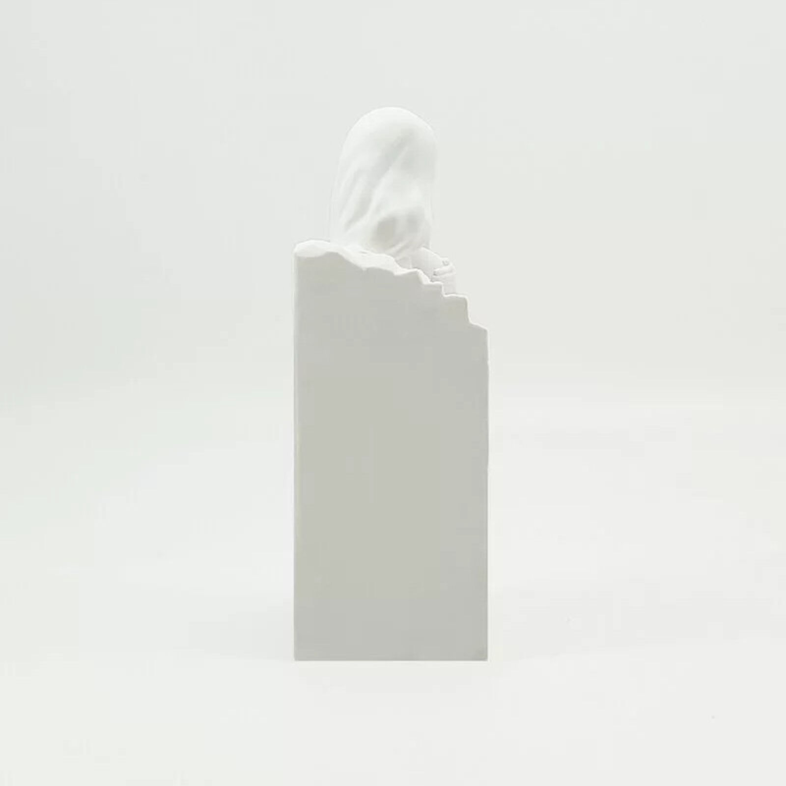 A white statue of a woman sitting on top of a box.