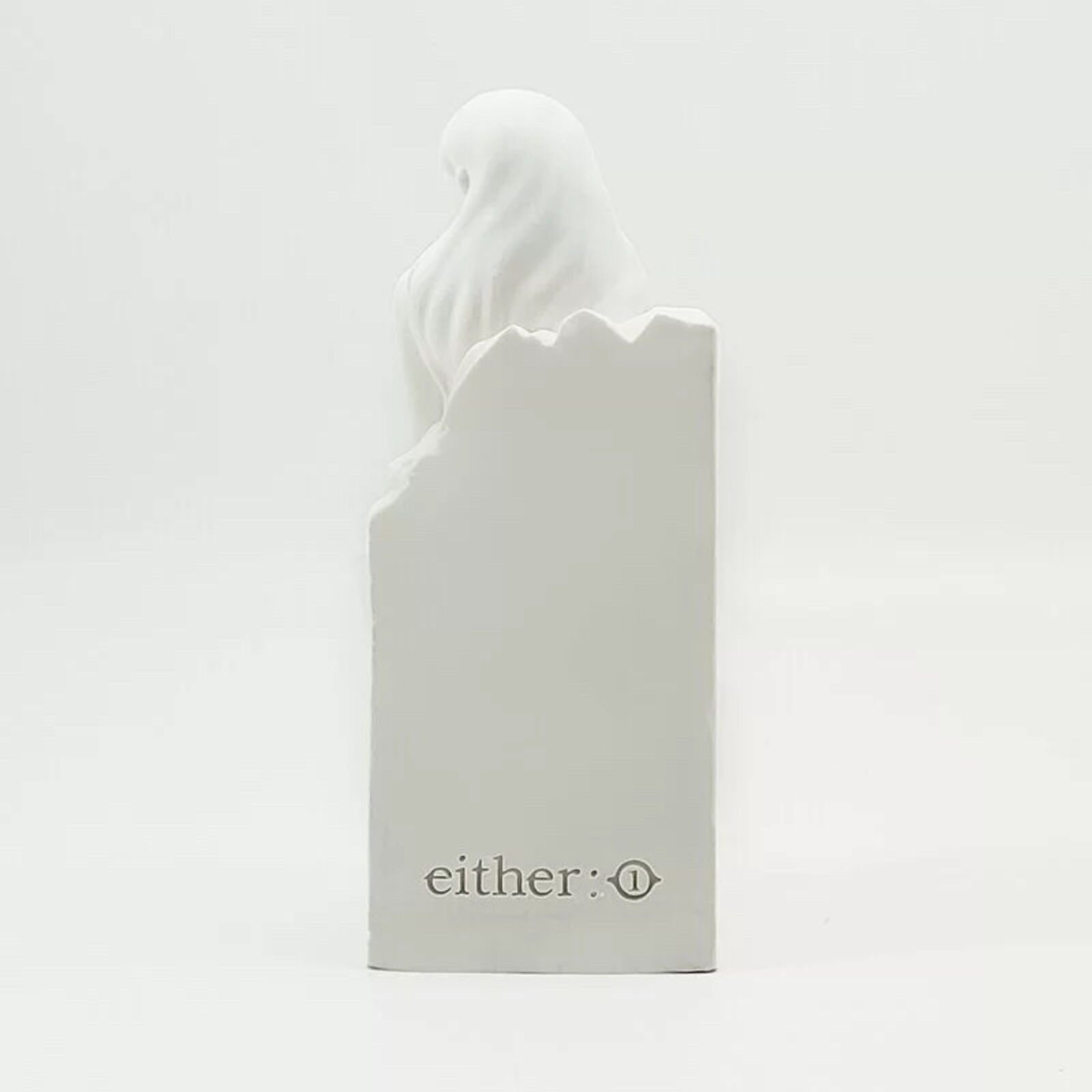 A white statue of a woman sitting on top of a box.