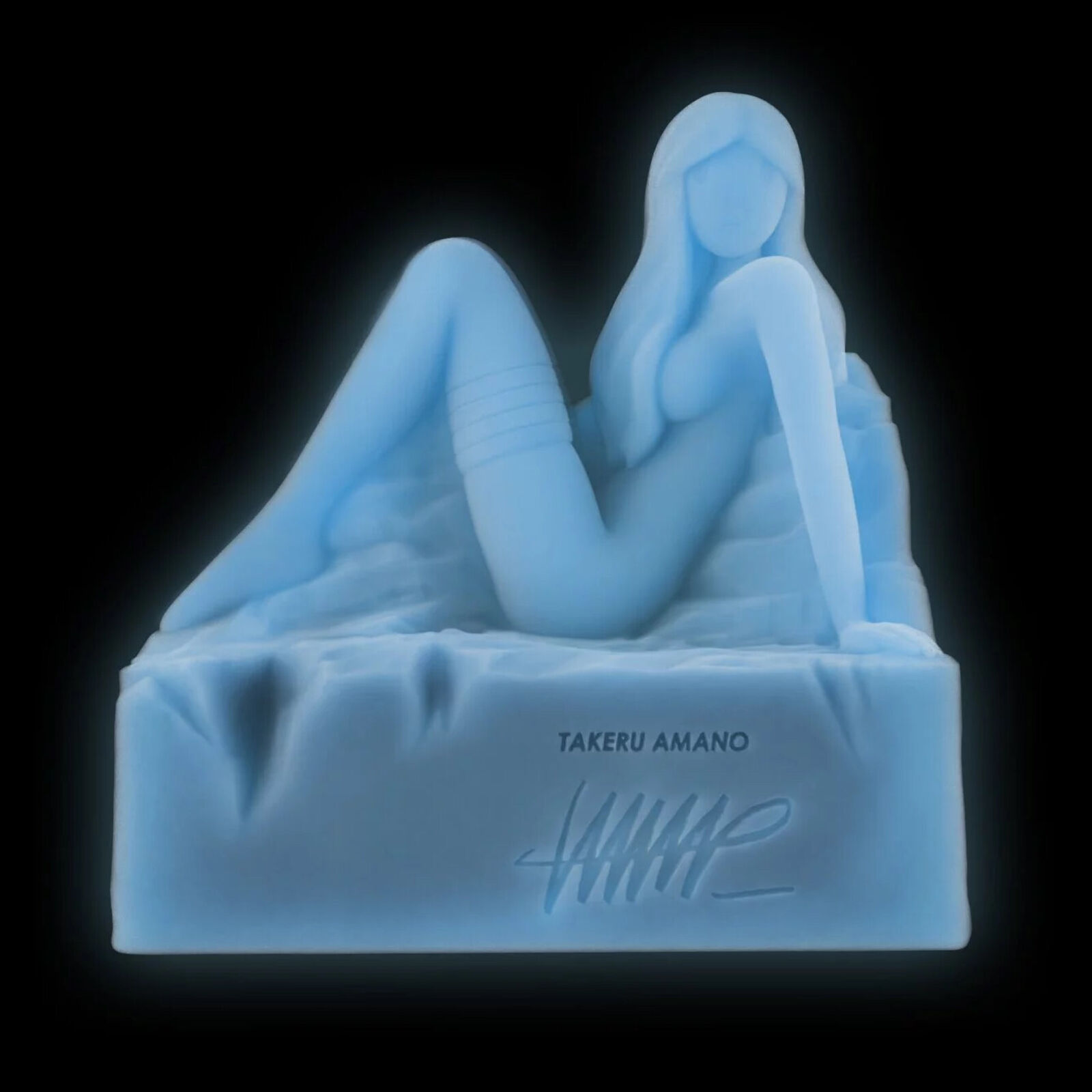 A white statue of a woman sitting on top of a rock.