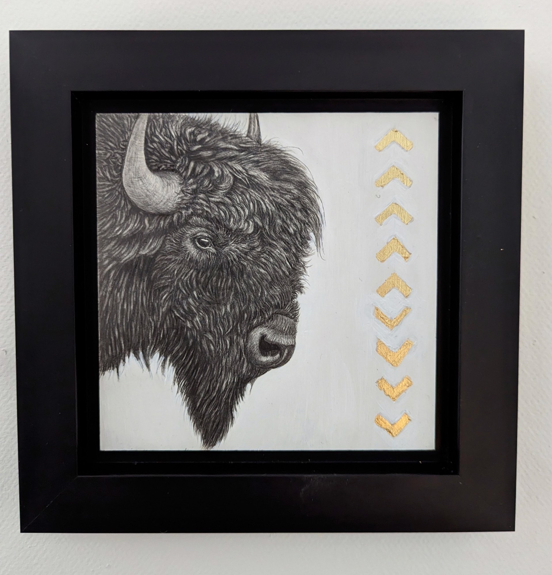 A drawing of a bison with gold arrows on it.