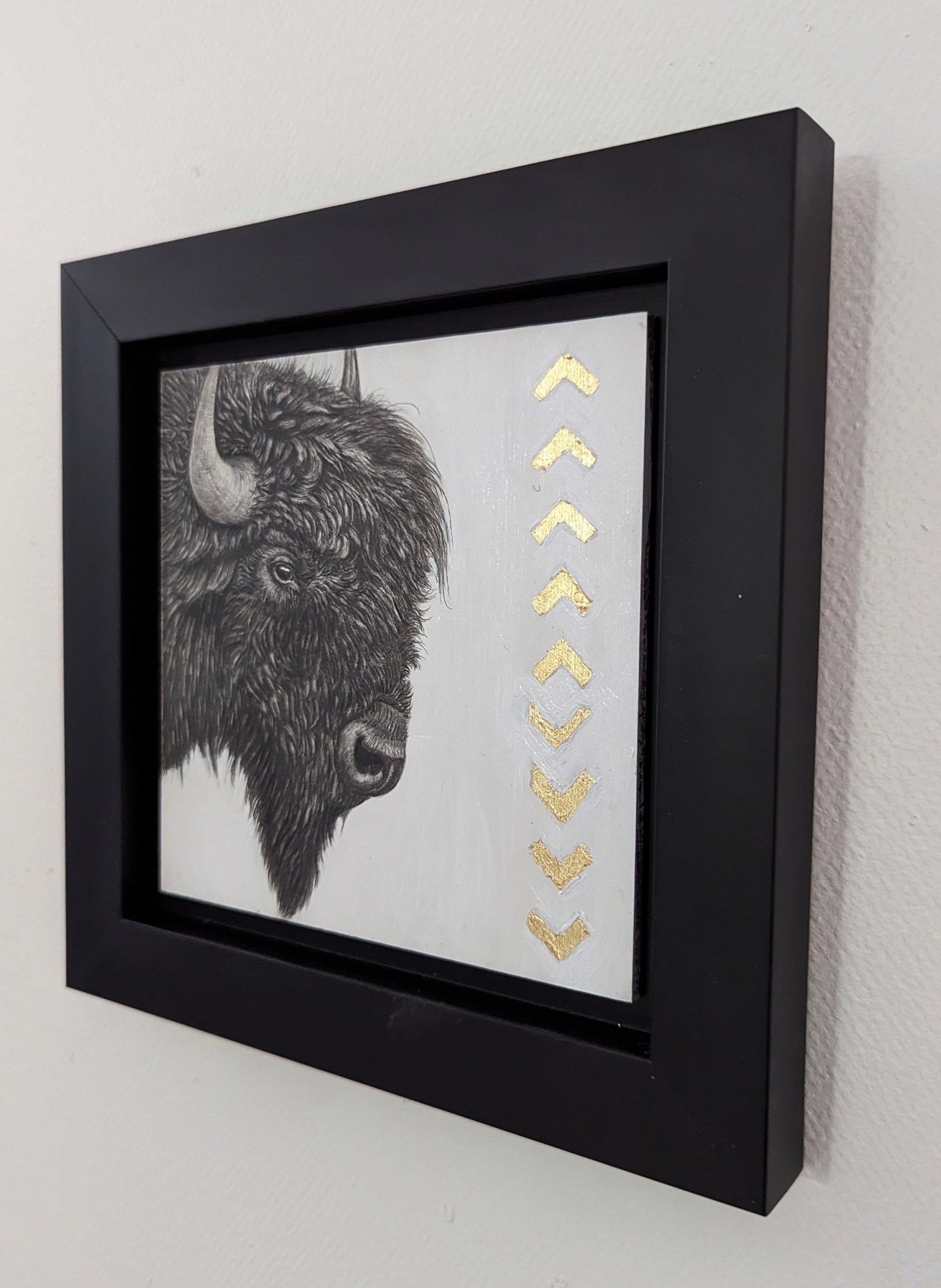 A drawing of a bison with gold arrows on it.
