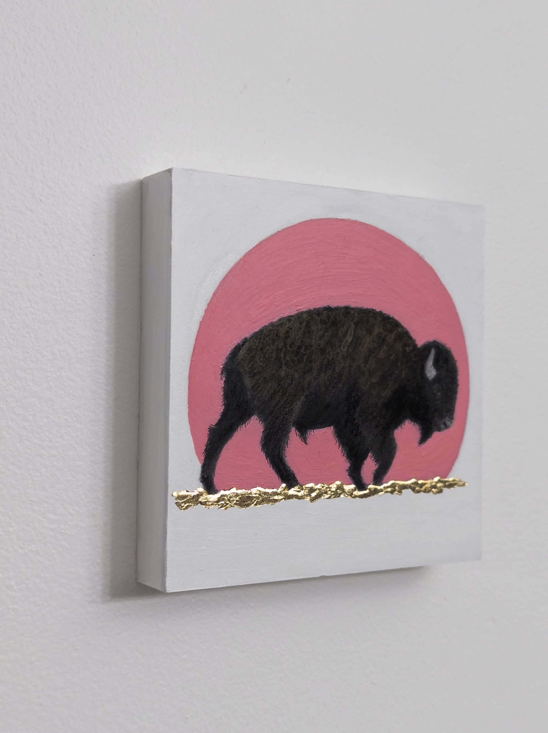 A painting of a bison standing in front of a pink sun.