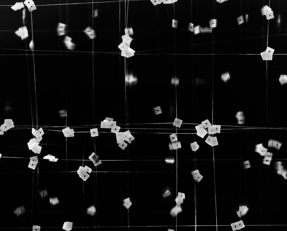 A black and white photo of confetti falling from the ceiling.