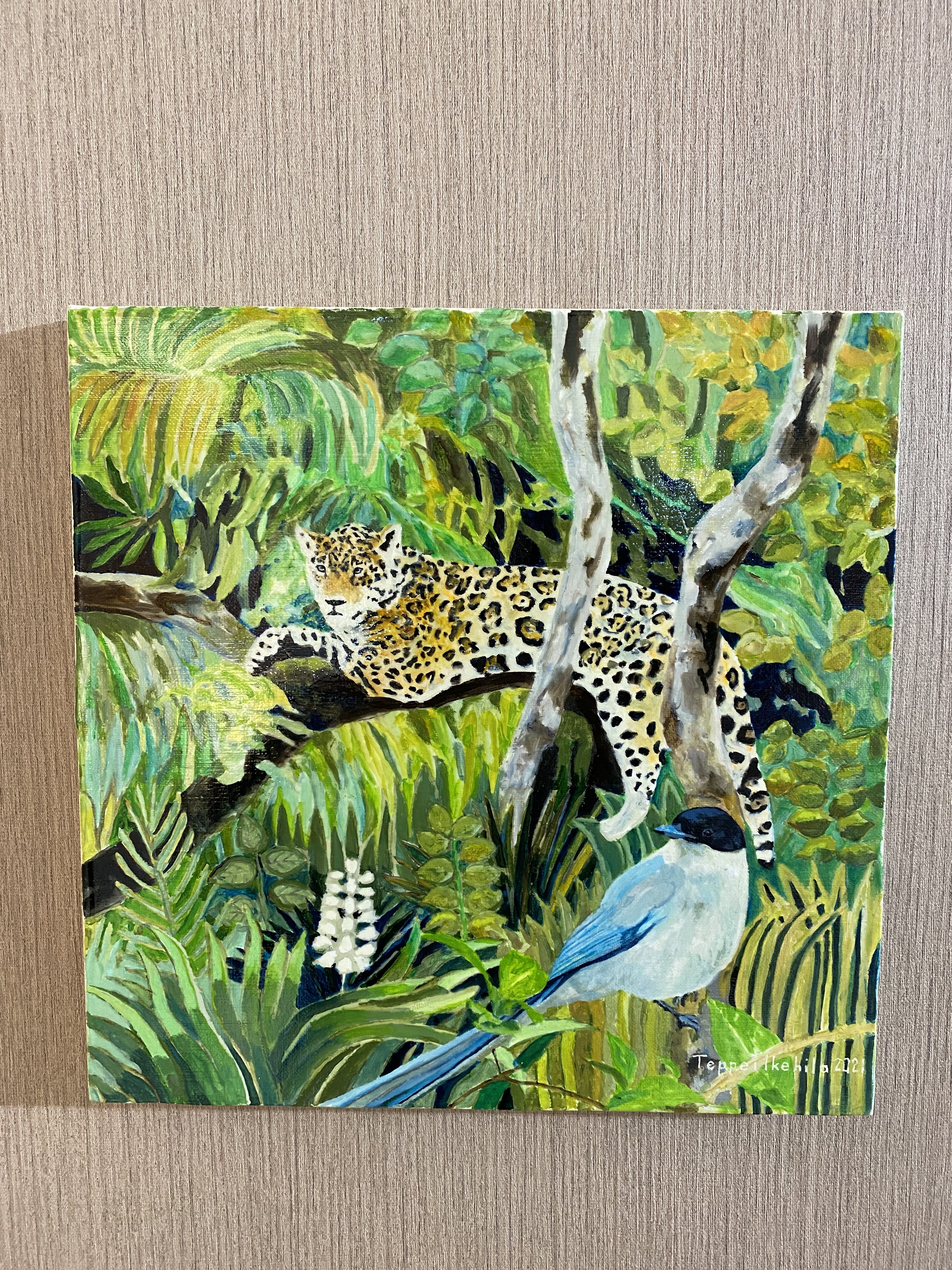 A vibrant painting of a spotted feline resting on a branch above a blue bird in a lush jungle.