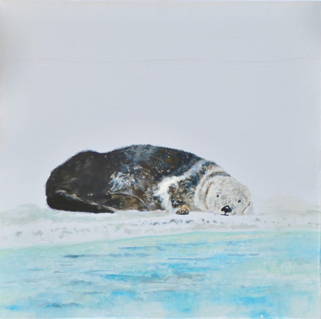 A solitary figure rests on a snowy surface near the water's edge.