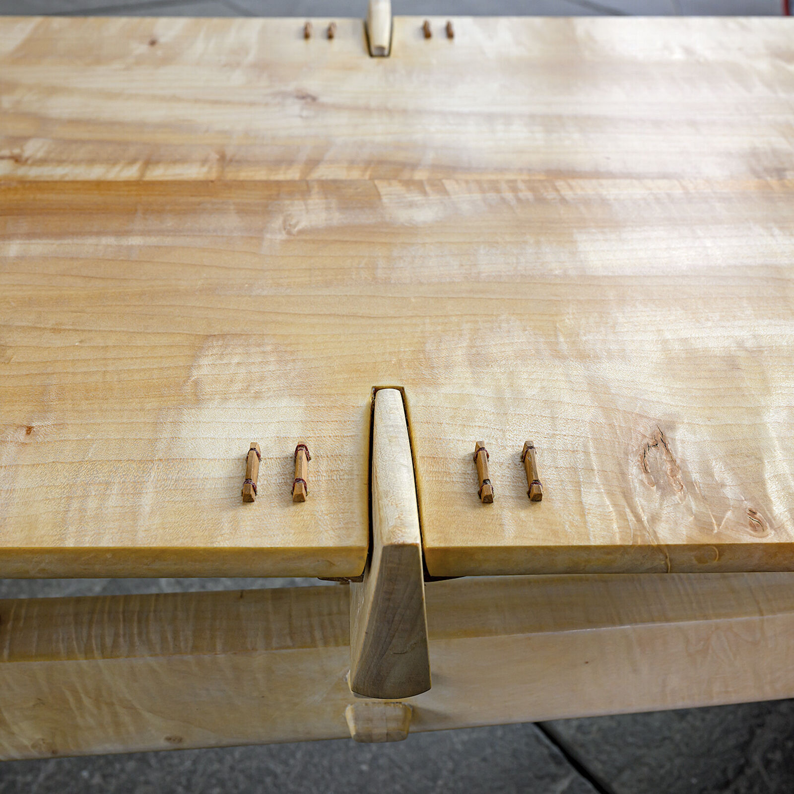 A minimalist wooden bench with a sleek design and natural wood tones.