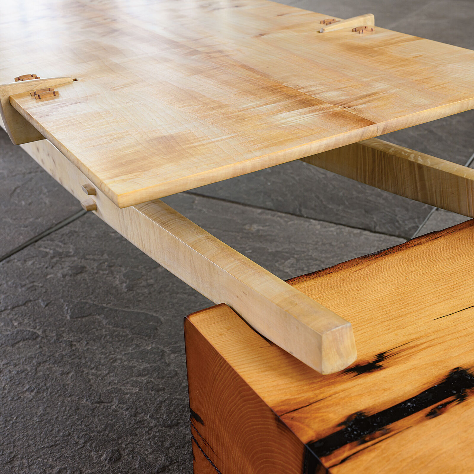 A minimalist wooden bench with a sleek design and natural wood tones.