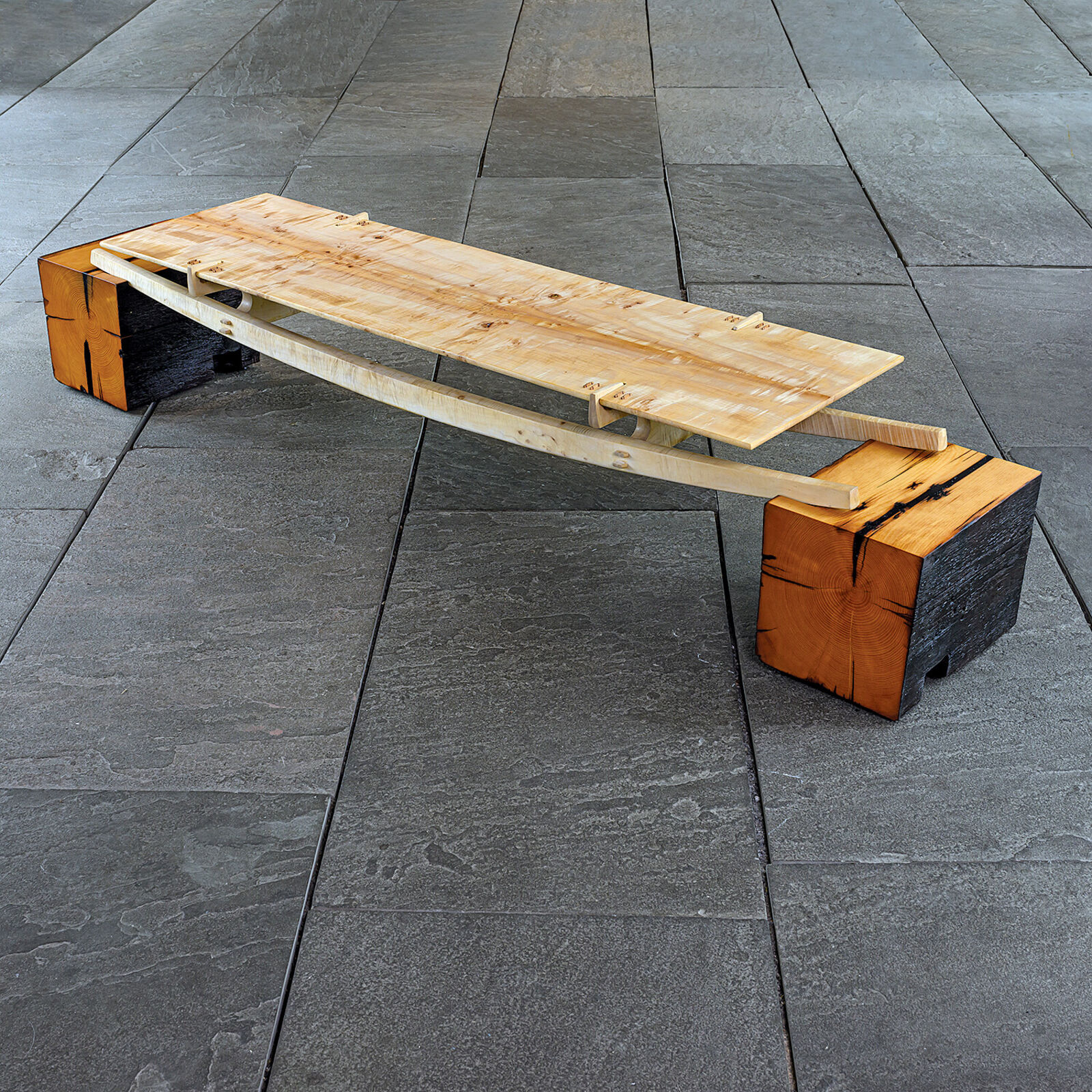 A minimalist wooden bench with a sleek design and natural wood tones.