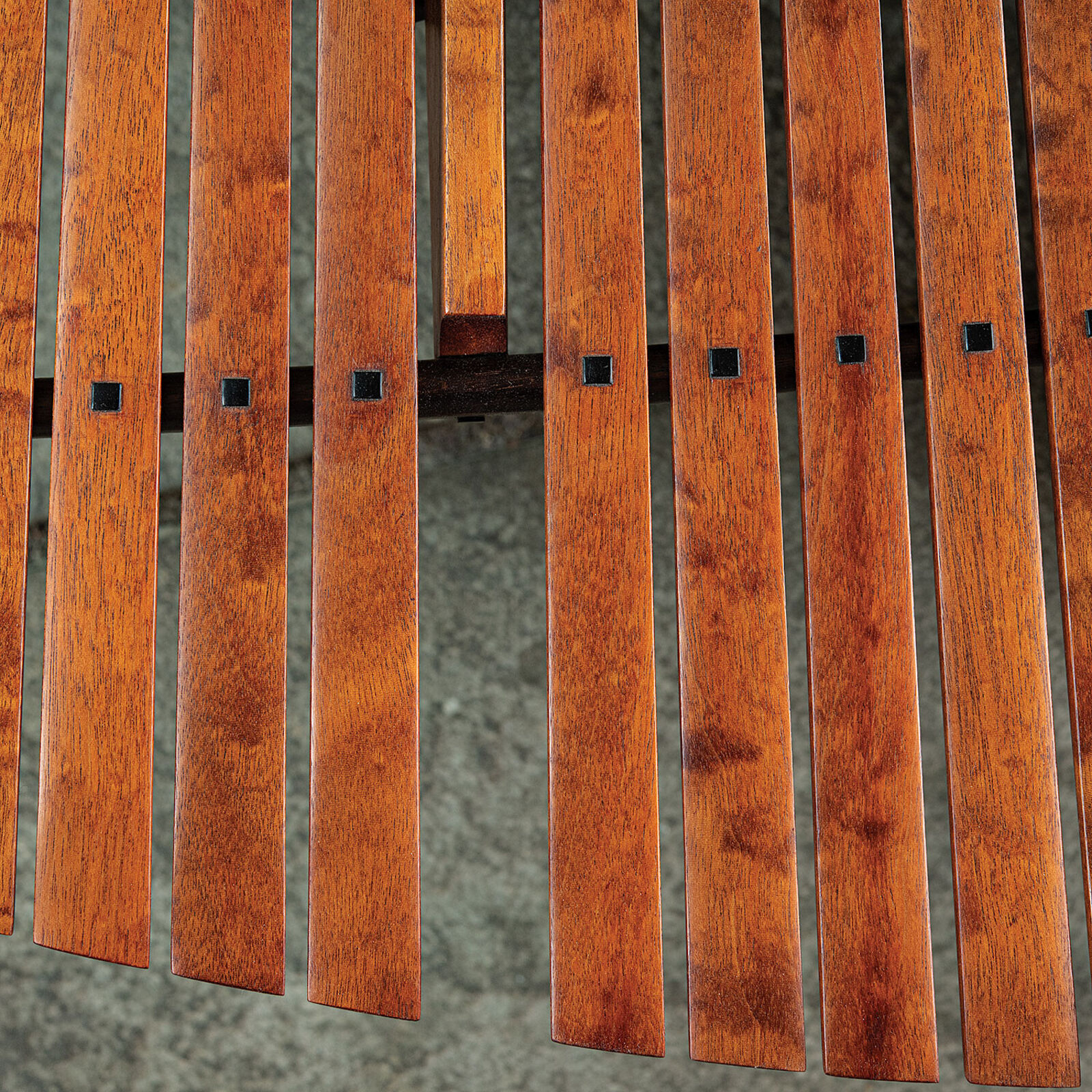 A modern wooden coffee table with a curved slatted top and sculpted black legs.