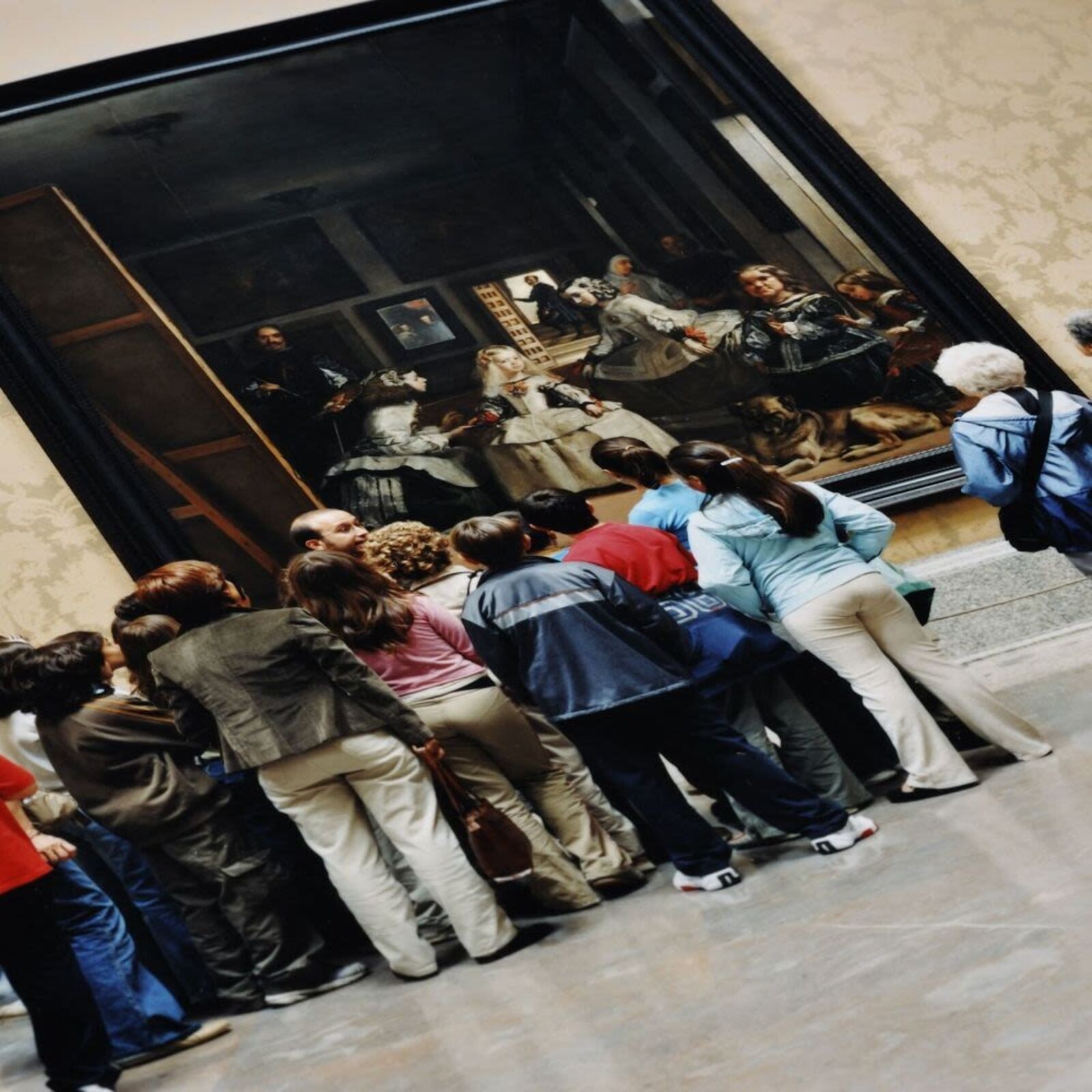 A group of people standing in front of a painting.