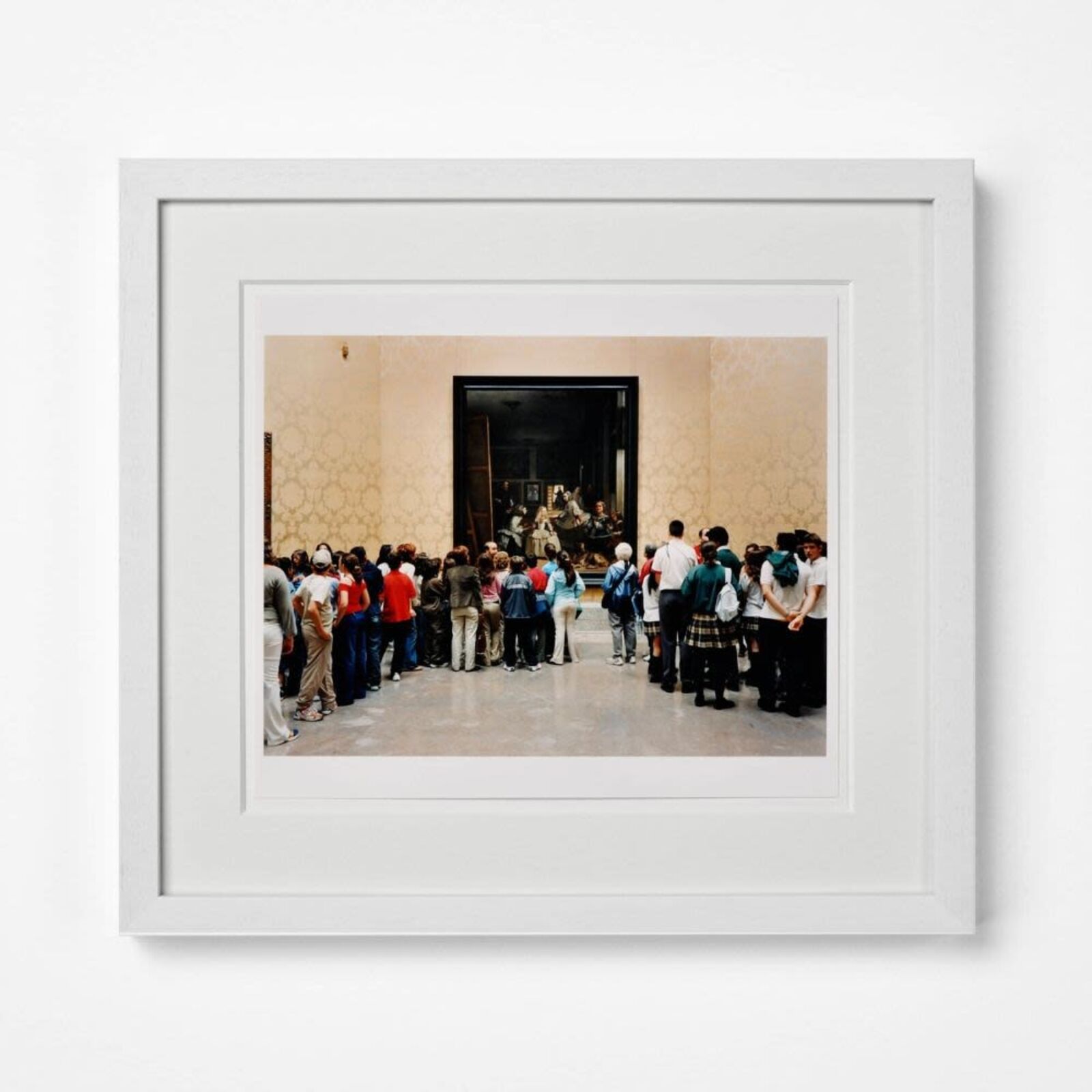 A group of people standing in front of a painting.