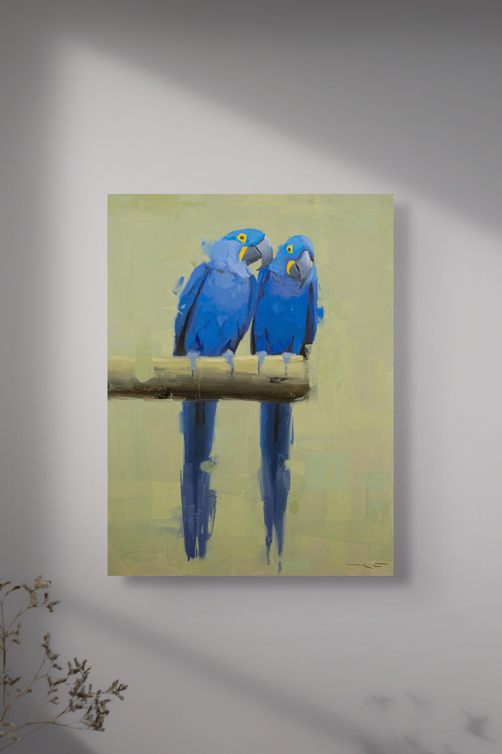 Two vivid blue parrots perch on a branch, their reflections mirrored in the water below.