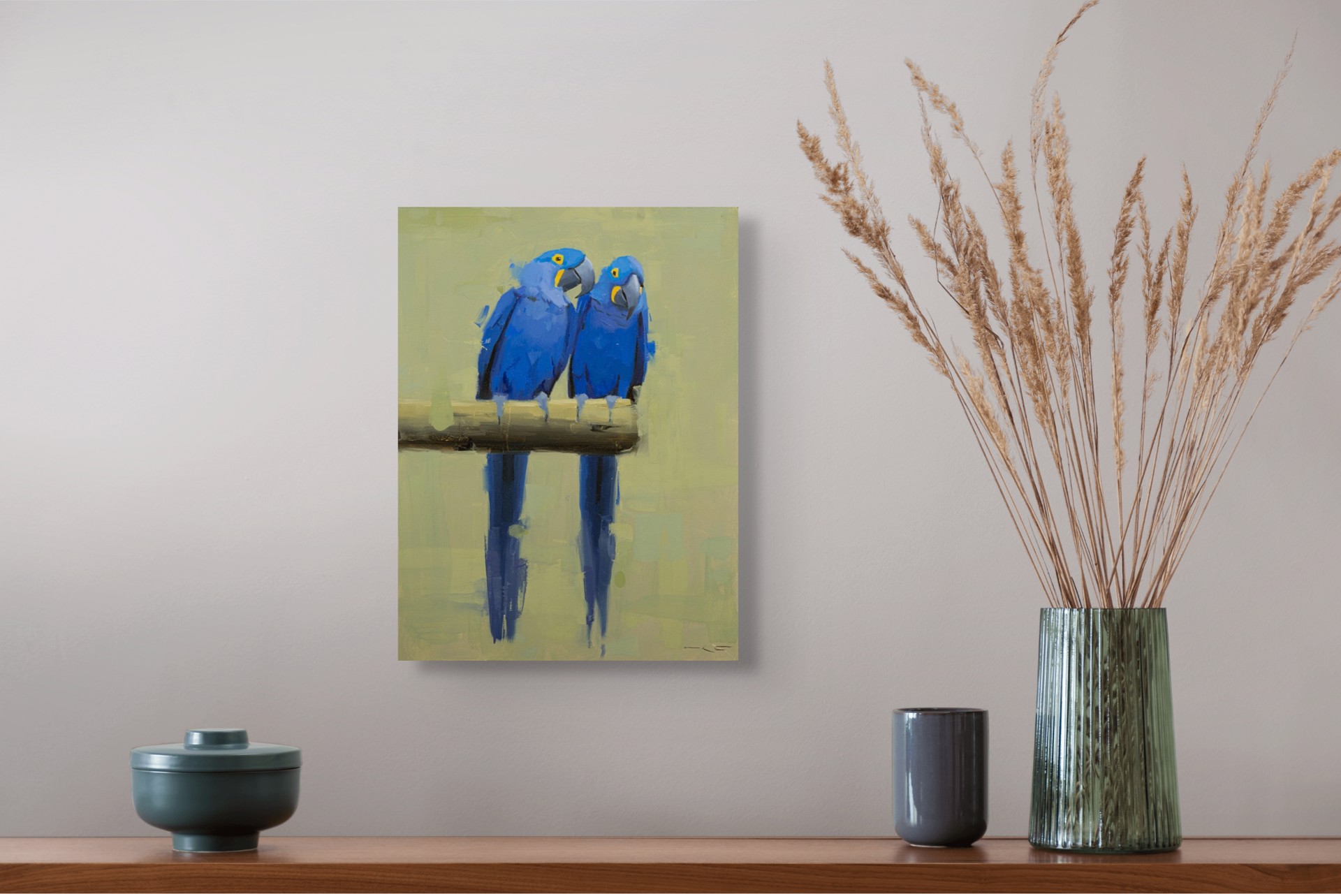 Two vivid blue parrots perch on a branch, their reflections mirrored in the water below.