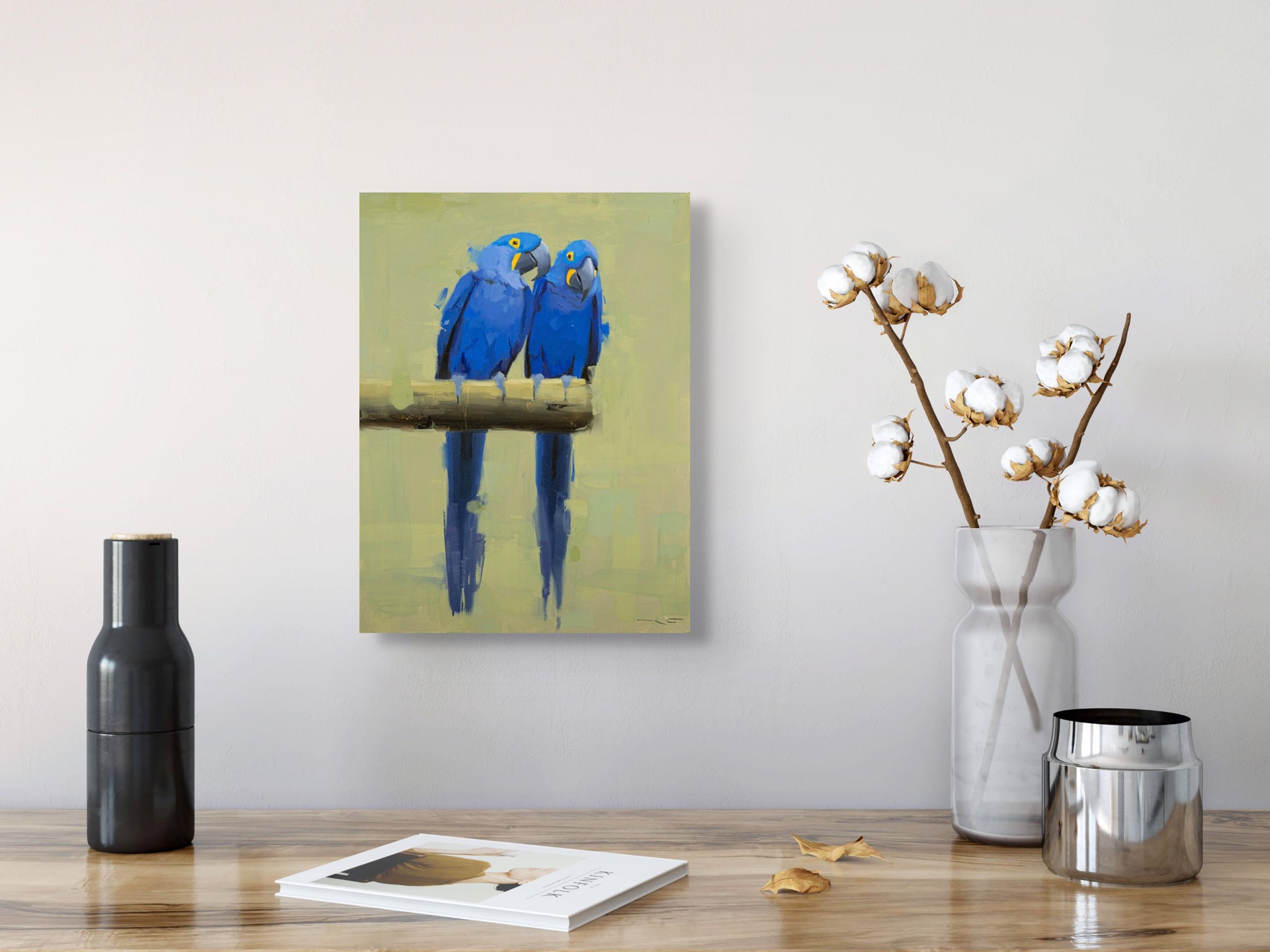 Two vivid blue parrots perch on a branch, their reflections mirrored in the water below.