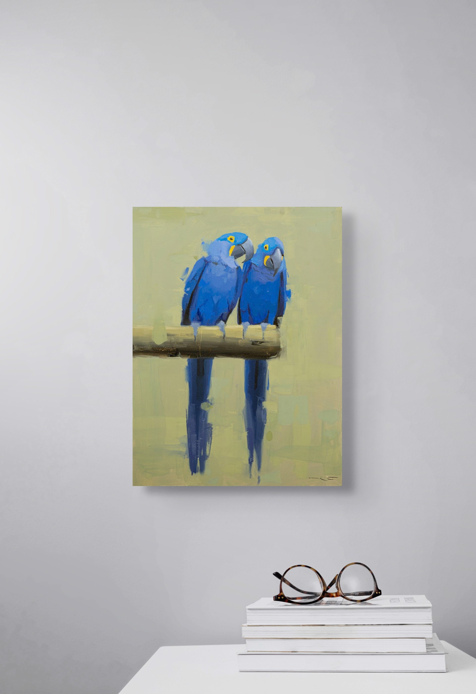 Two vivid blue parrots perch on a branch, their reflections mirrored in the water below.