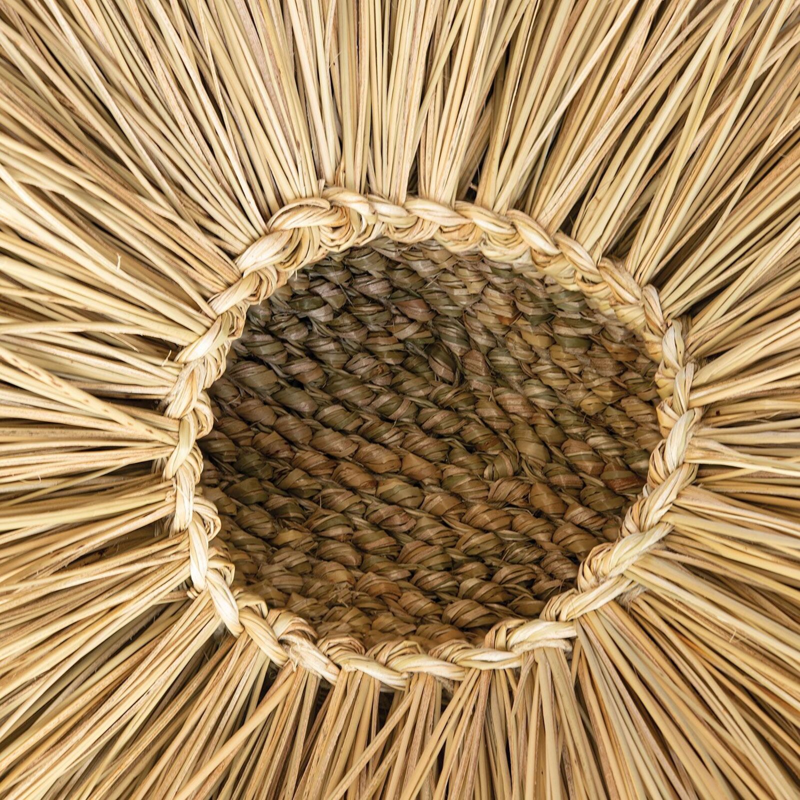 A close-up of a woven basket interior with radiating straw spokes.