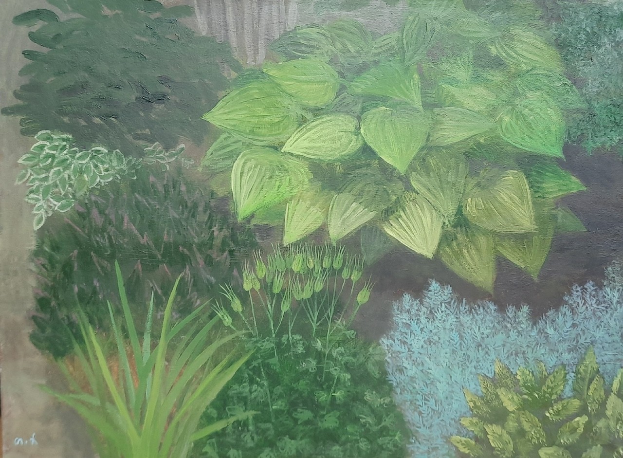 A lush garden scene filled with varied green foliage and textured plants.