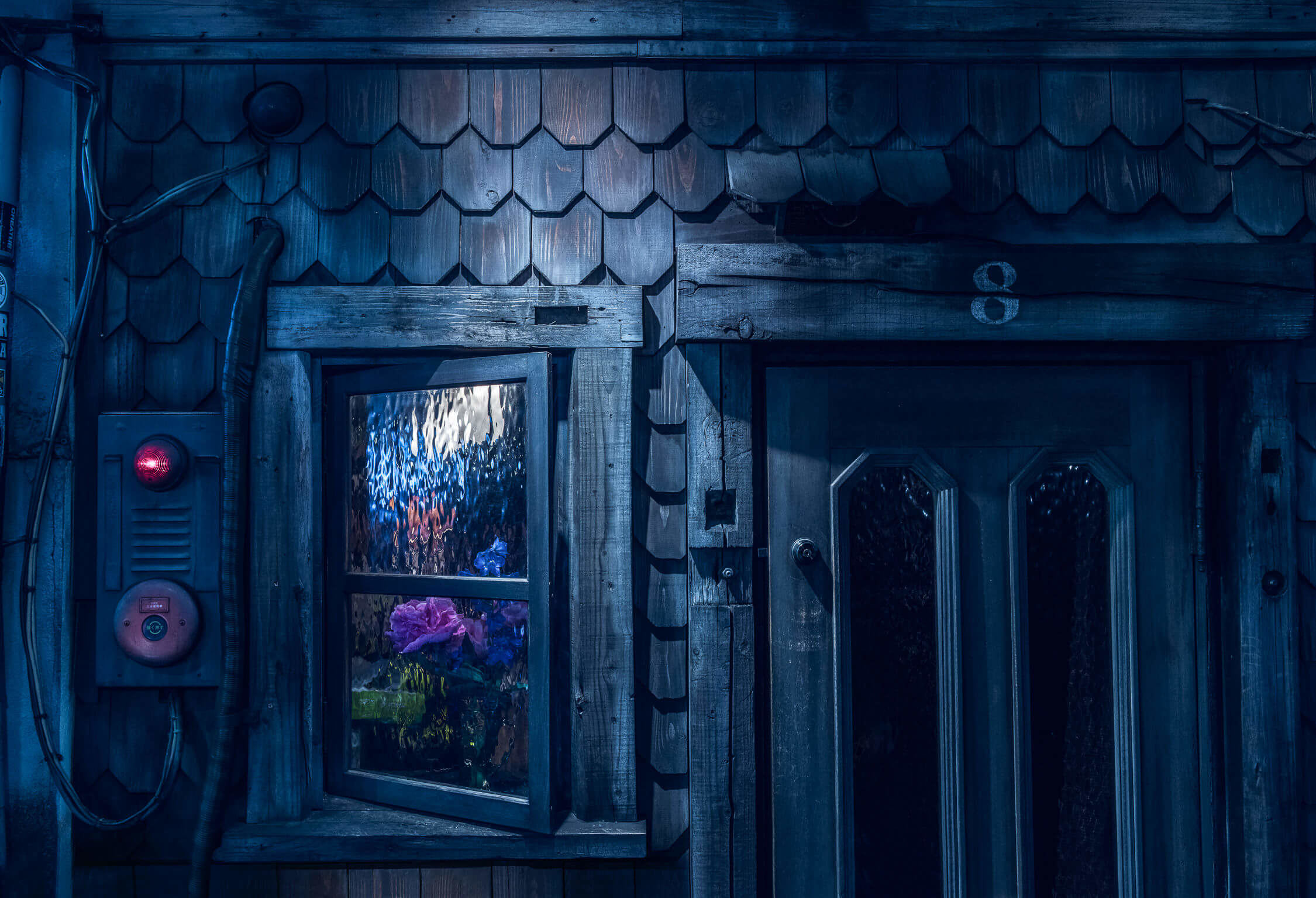 A wooden house with a window and a door in the dark.