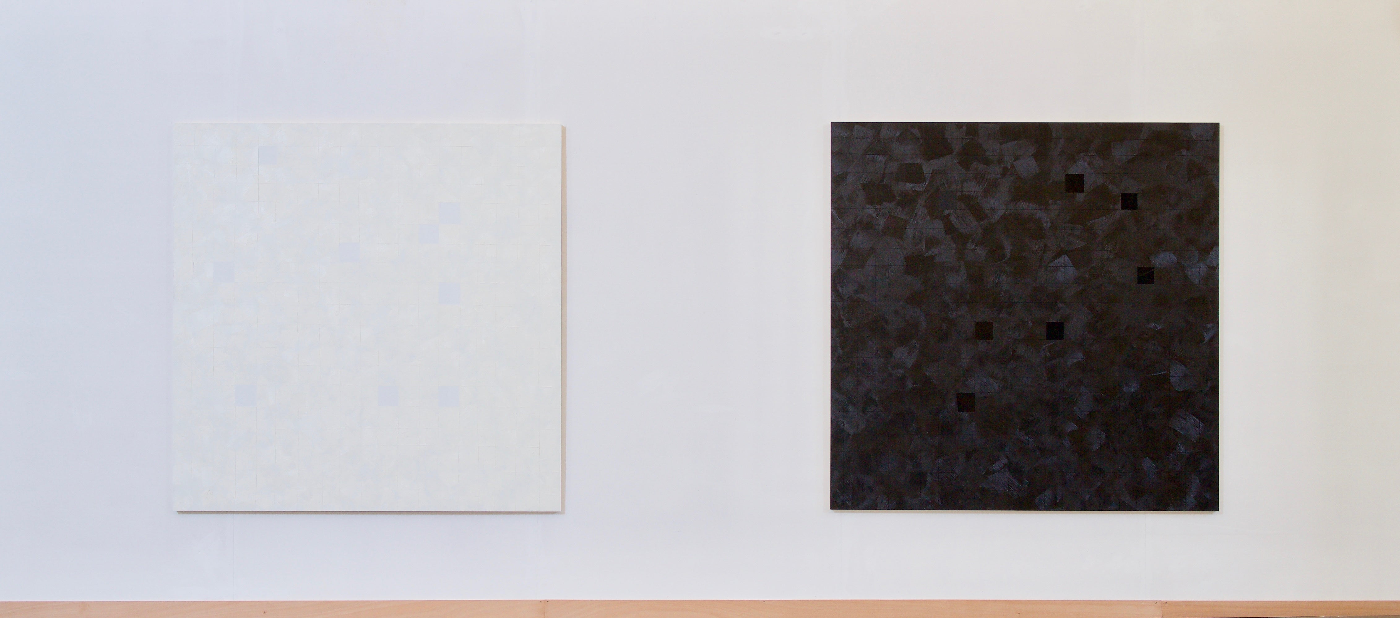 A black painting on a white wall with black squares.