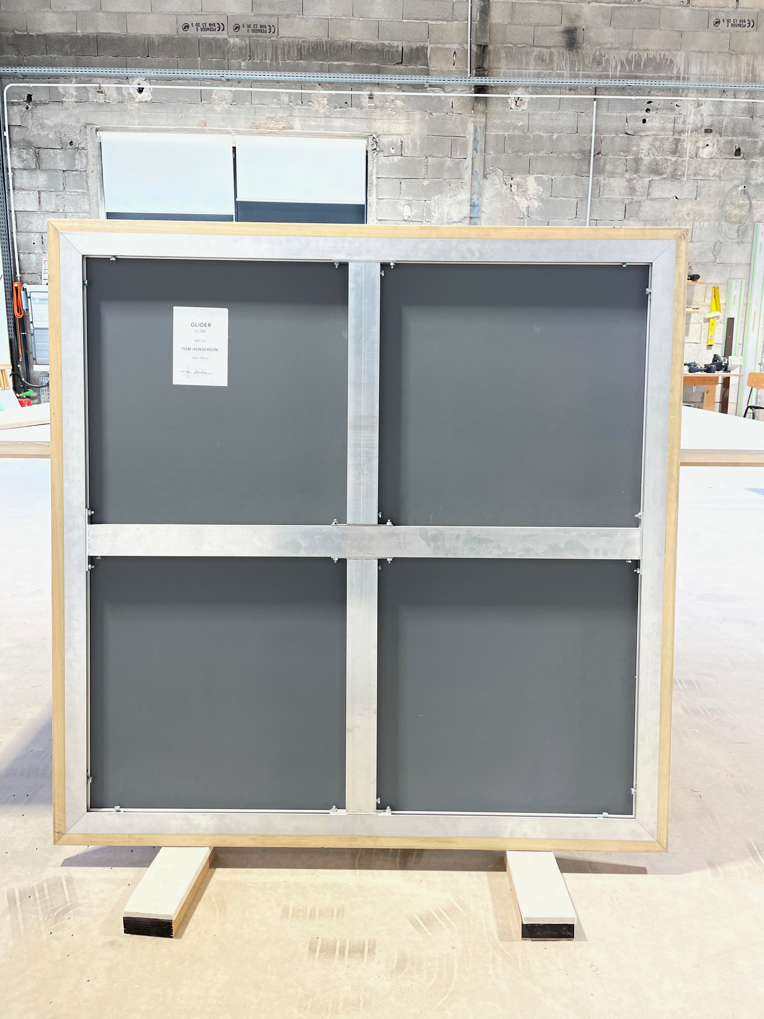 A black painting on a white wall with black squares.