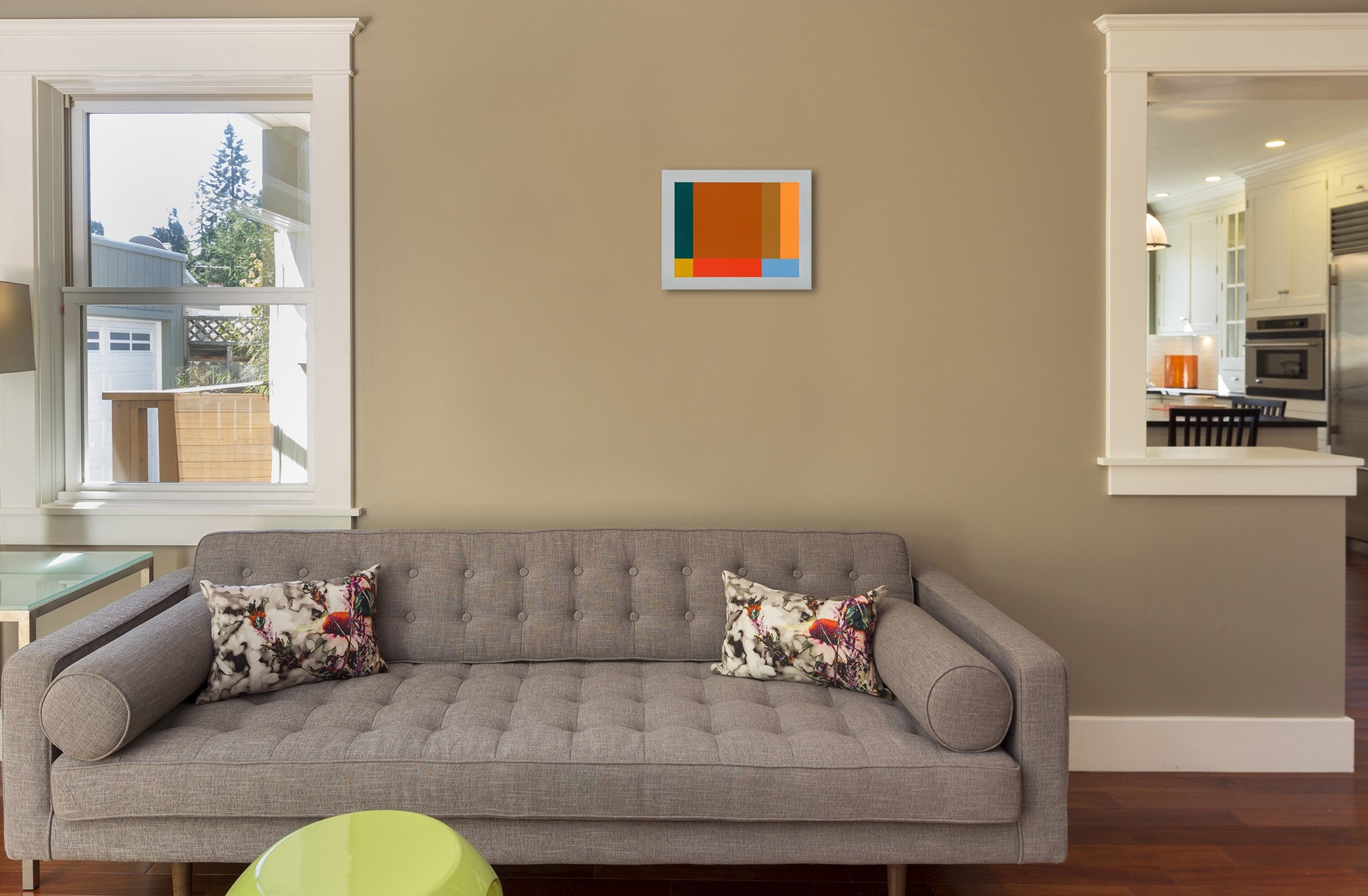 An orange, blue, and green painting on a white wall.