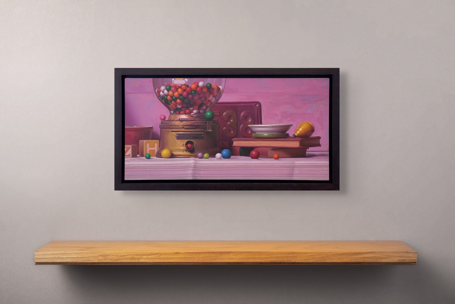 A colorful still life featuring a vintage gumball machine, books, and scattered spheres against a soft pink backdrop.