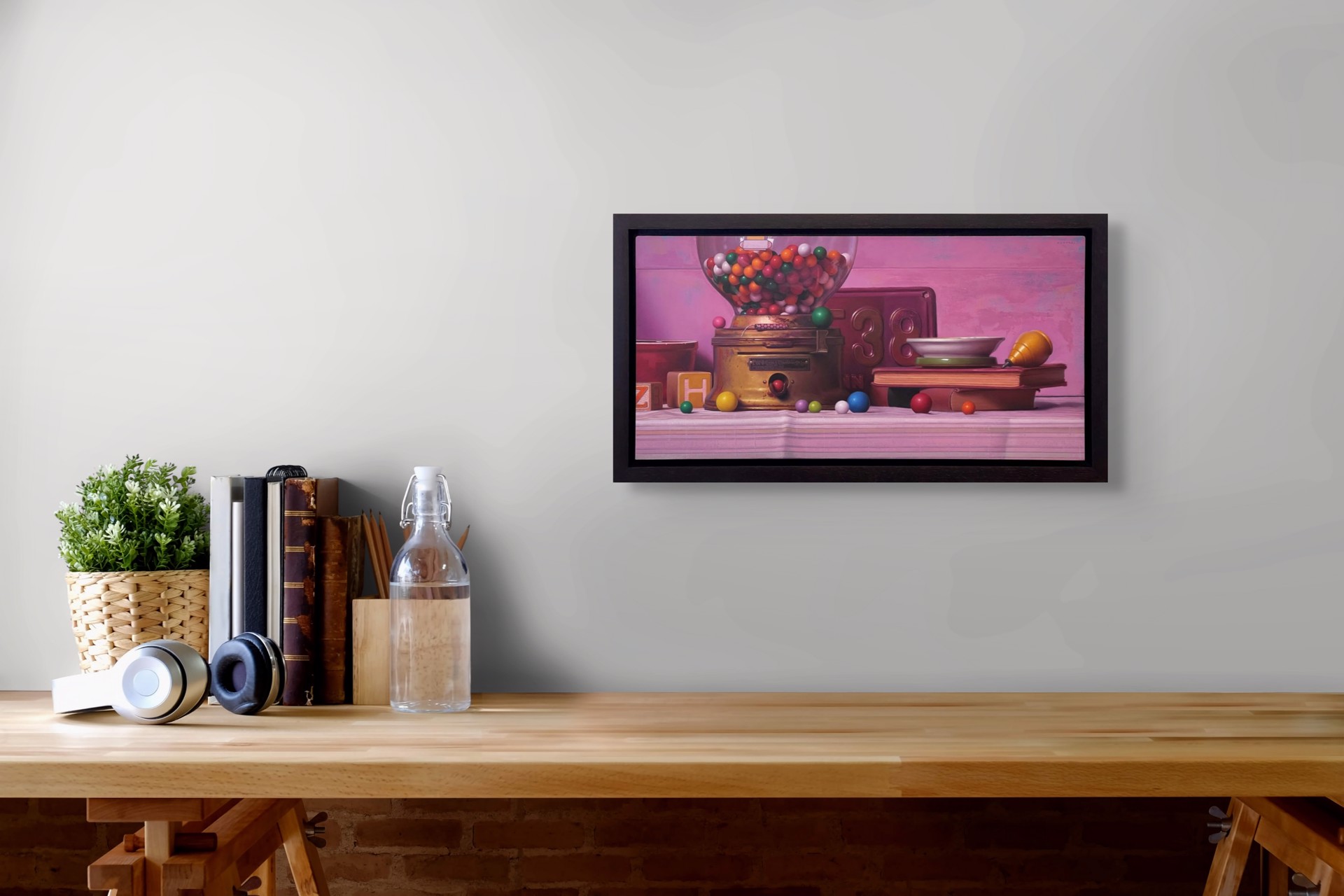 A colorful still life featuring a vintage gumball machine, books, and scattered spheres against a soft pink backdrop.