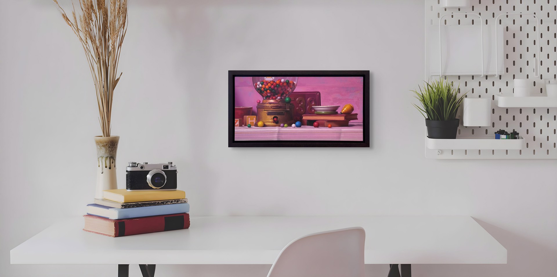 A colorful still life featuring a vintage gumball machine, books, and scattered spheres against a soft pink backdrop.