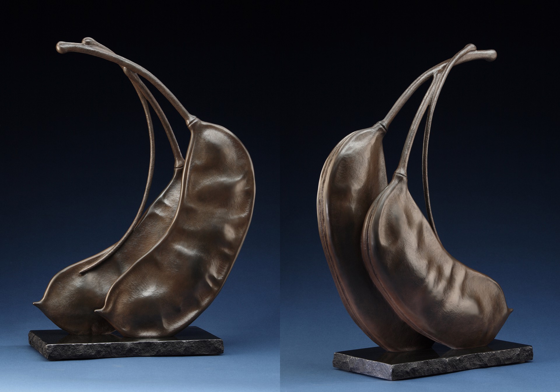 A bronze sculpture of two peaches on a marble base.