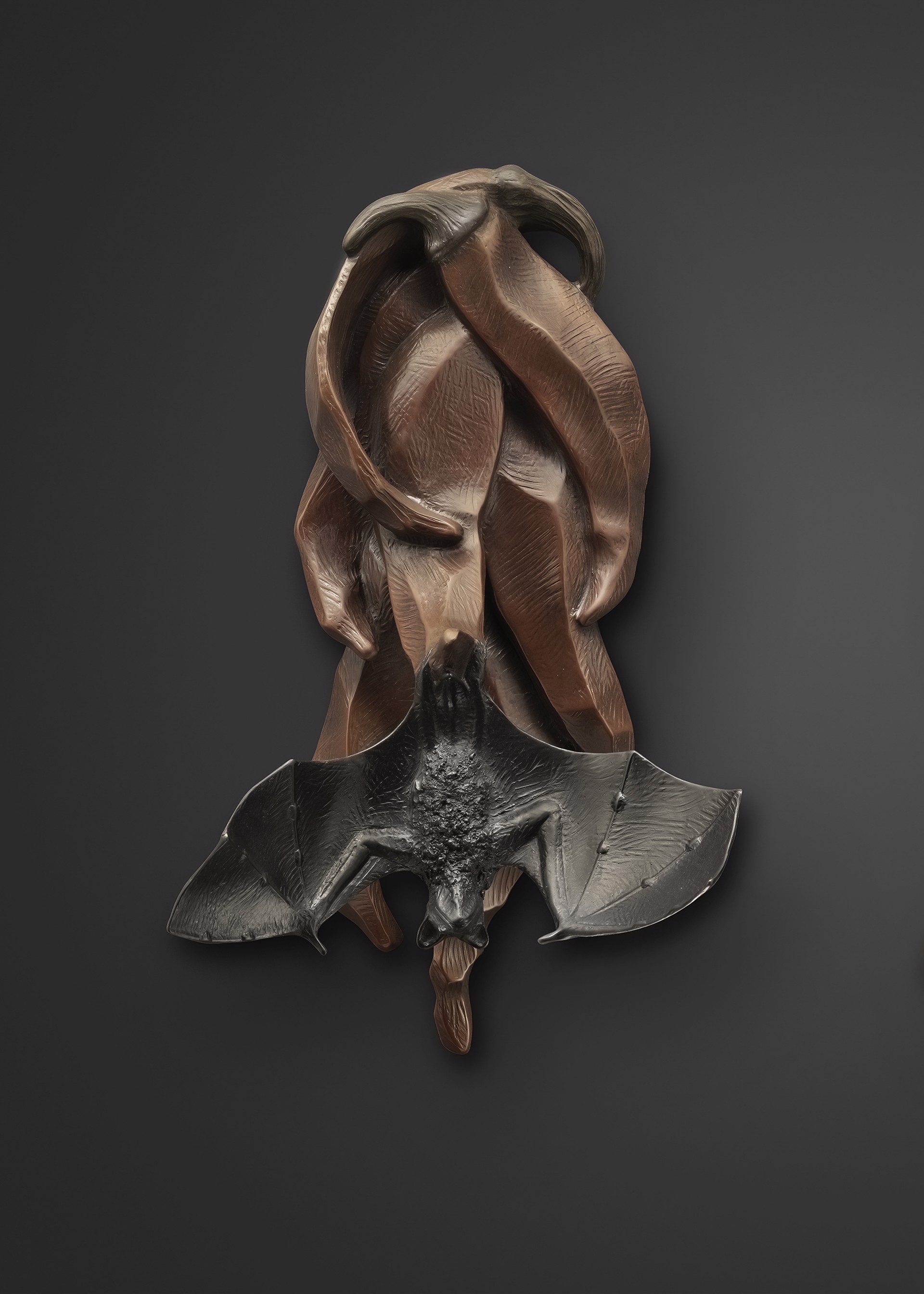 A bronze sculpture of a bat on a black background.