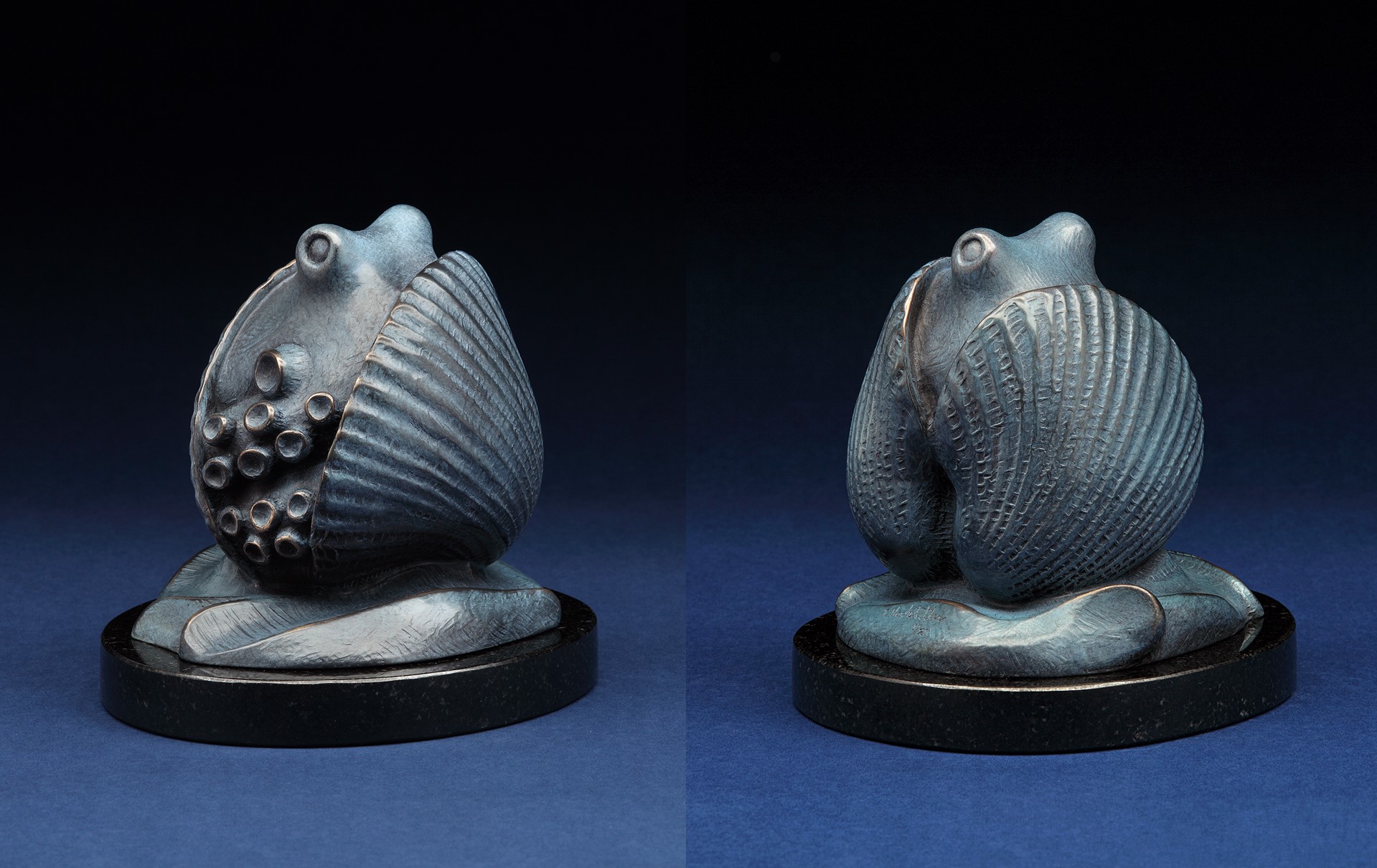 A pair of figurines of a frog sitting on top of a shell.