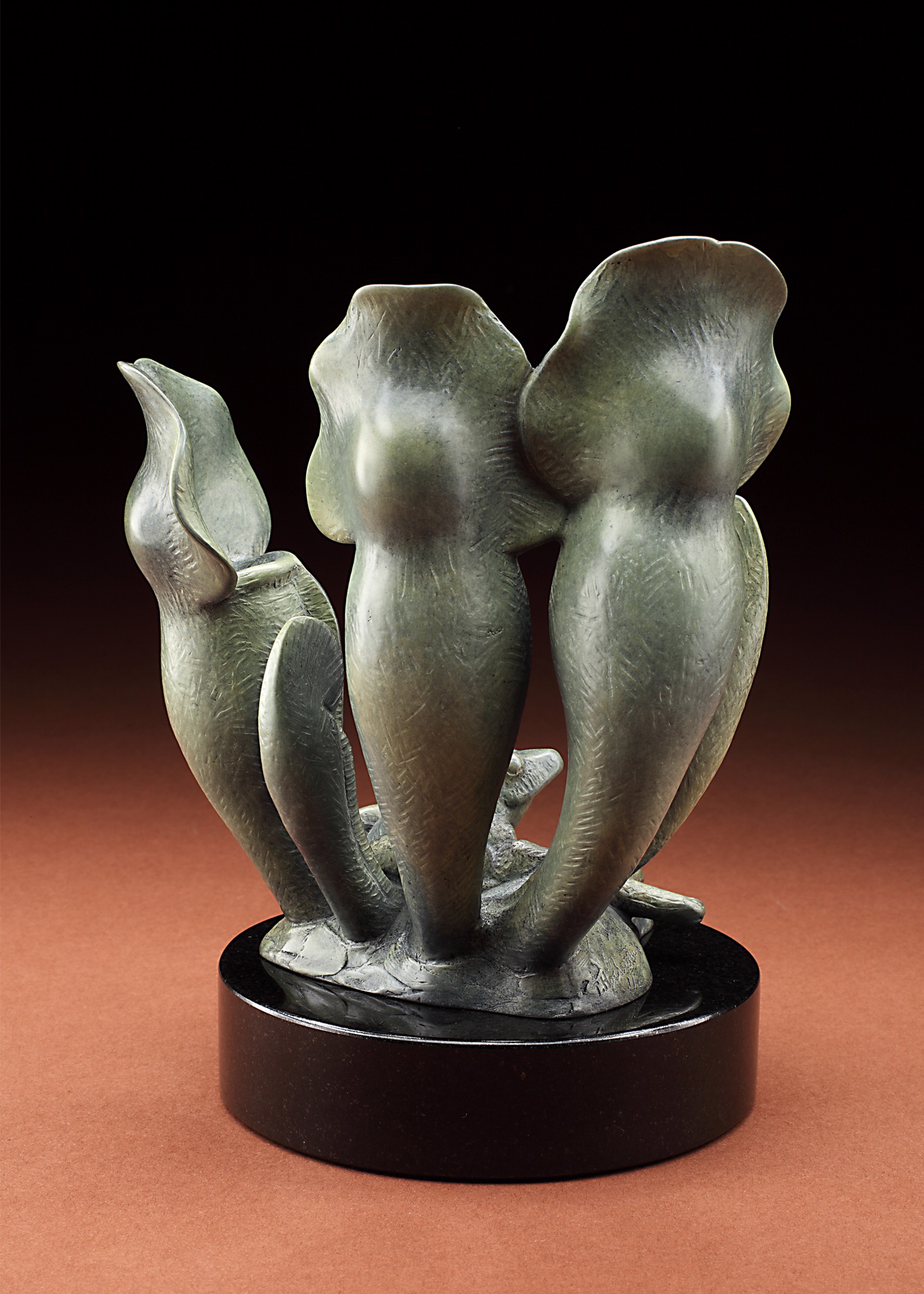 A sculptural piece featuring three pitcher plants surrounding a small frog.