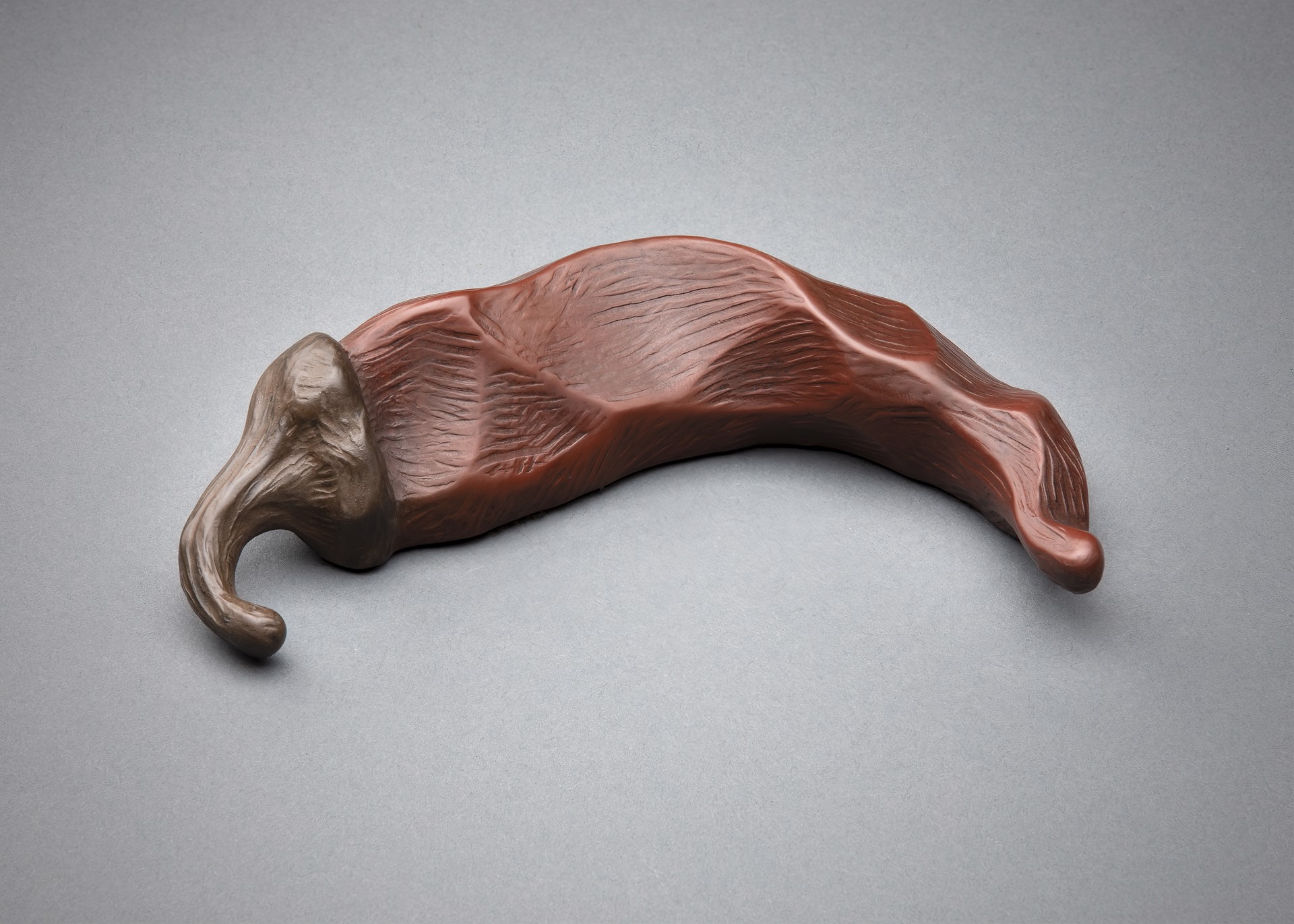 A sculptural object resembling a stylized chili pepper with an elephant head.