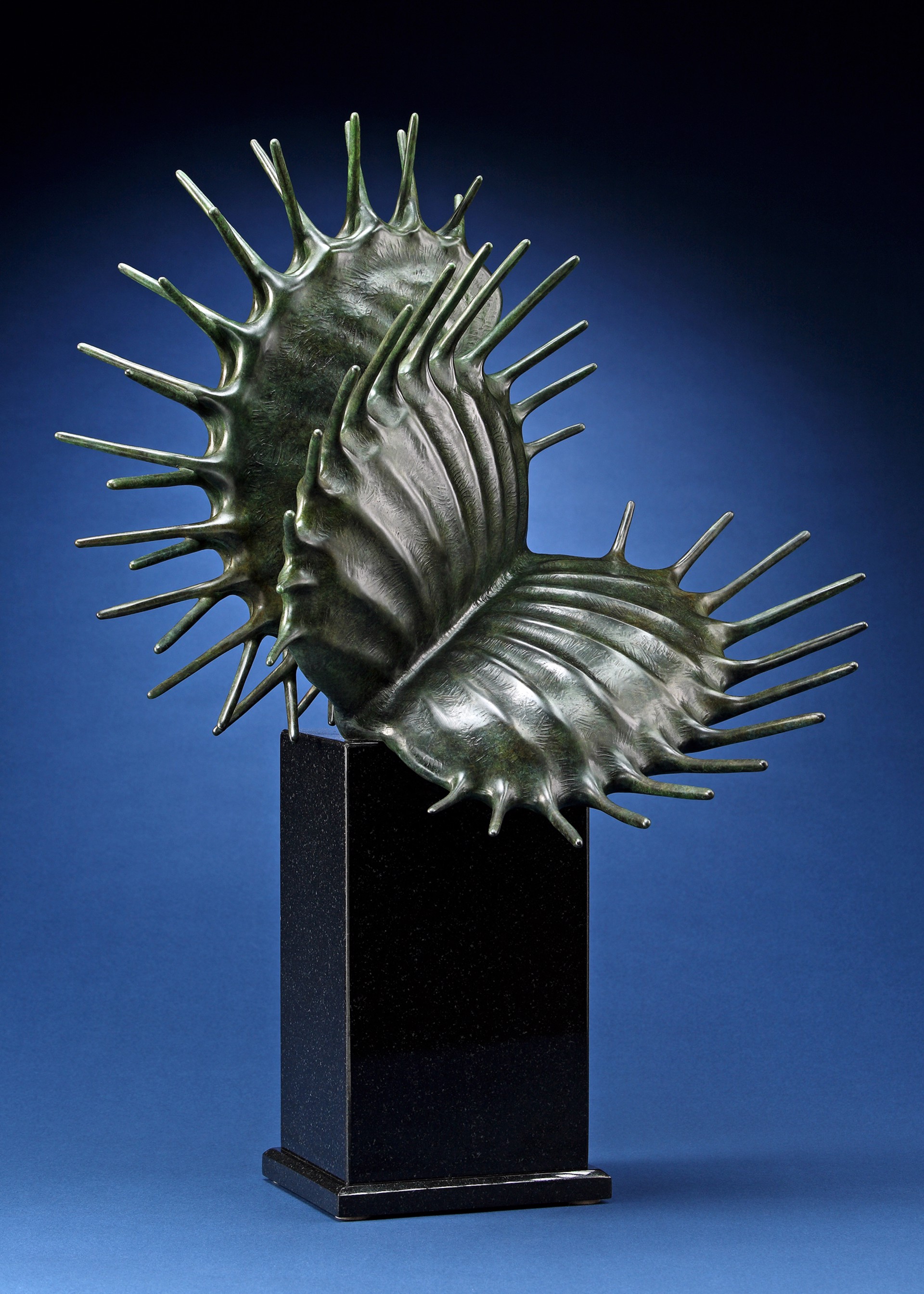 A bronze sculpture of a sea urchin on a black pedestal.