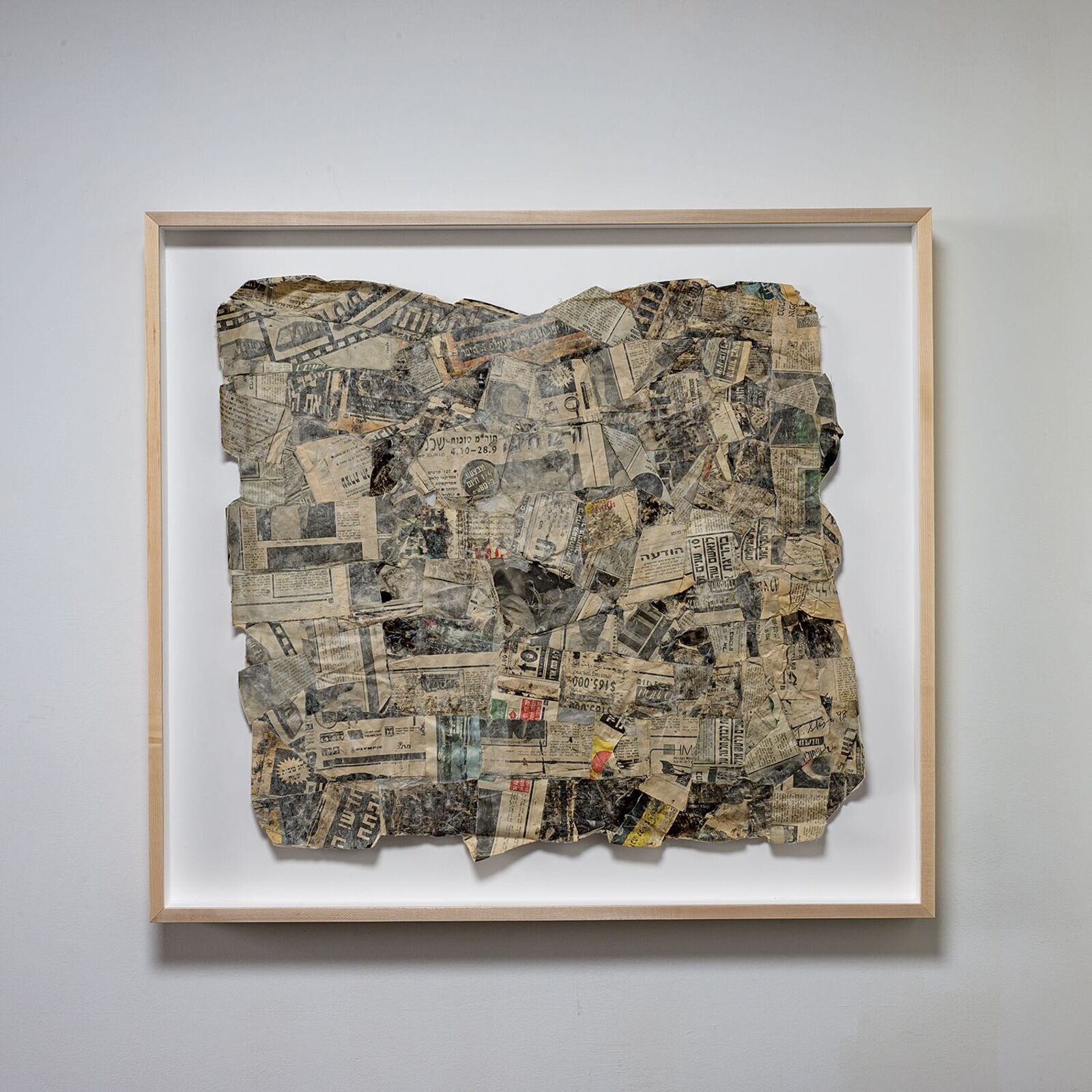 A framed collage of aged, torn paper fragments arranged in a rough square shape.