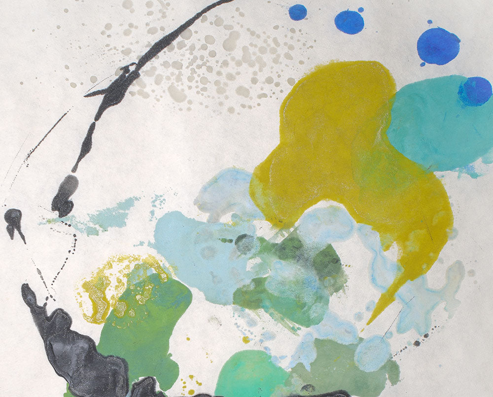 A painting on a white wall with blue and yellow paint splatters.