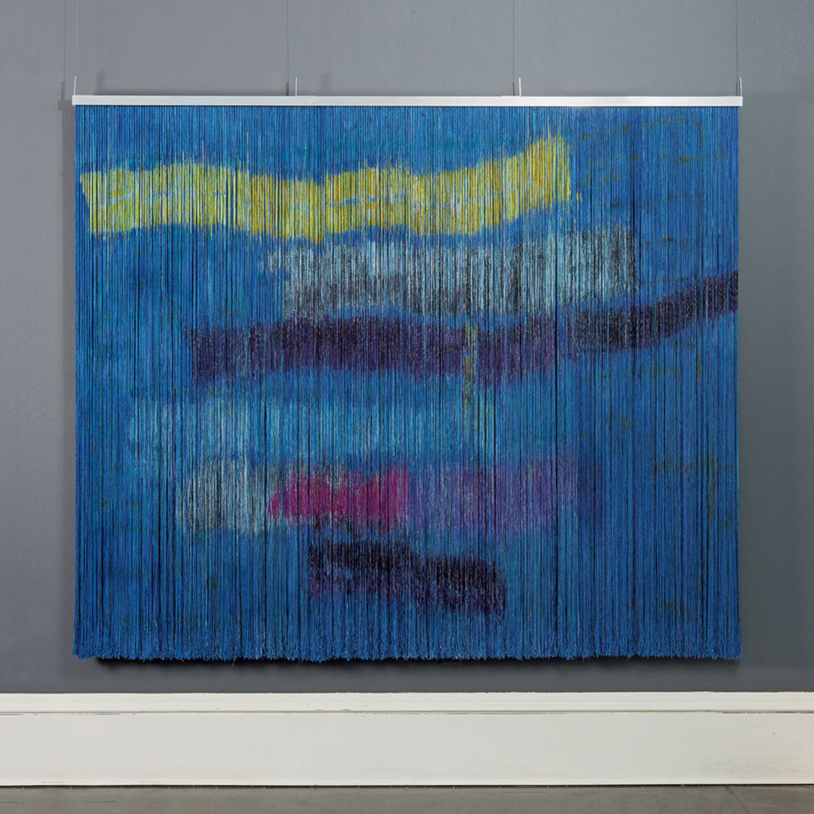 A large blue and yellow painting hanging on a wall.