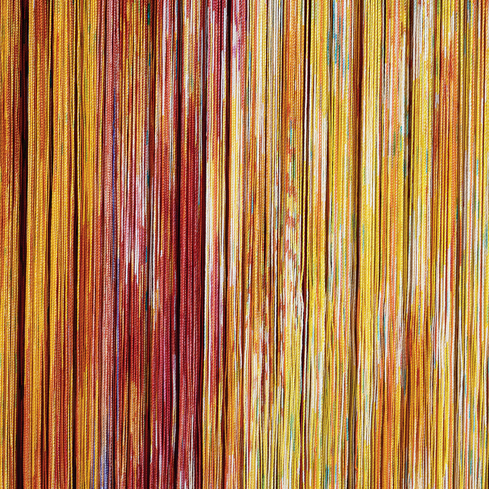 A wall hanging on a wall next to a window.