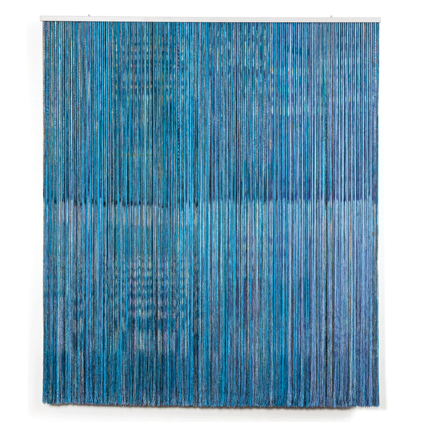 A blue and white wall hanging on a white wall.