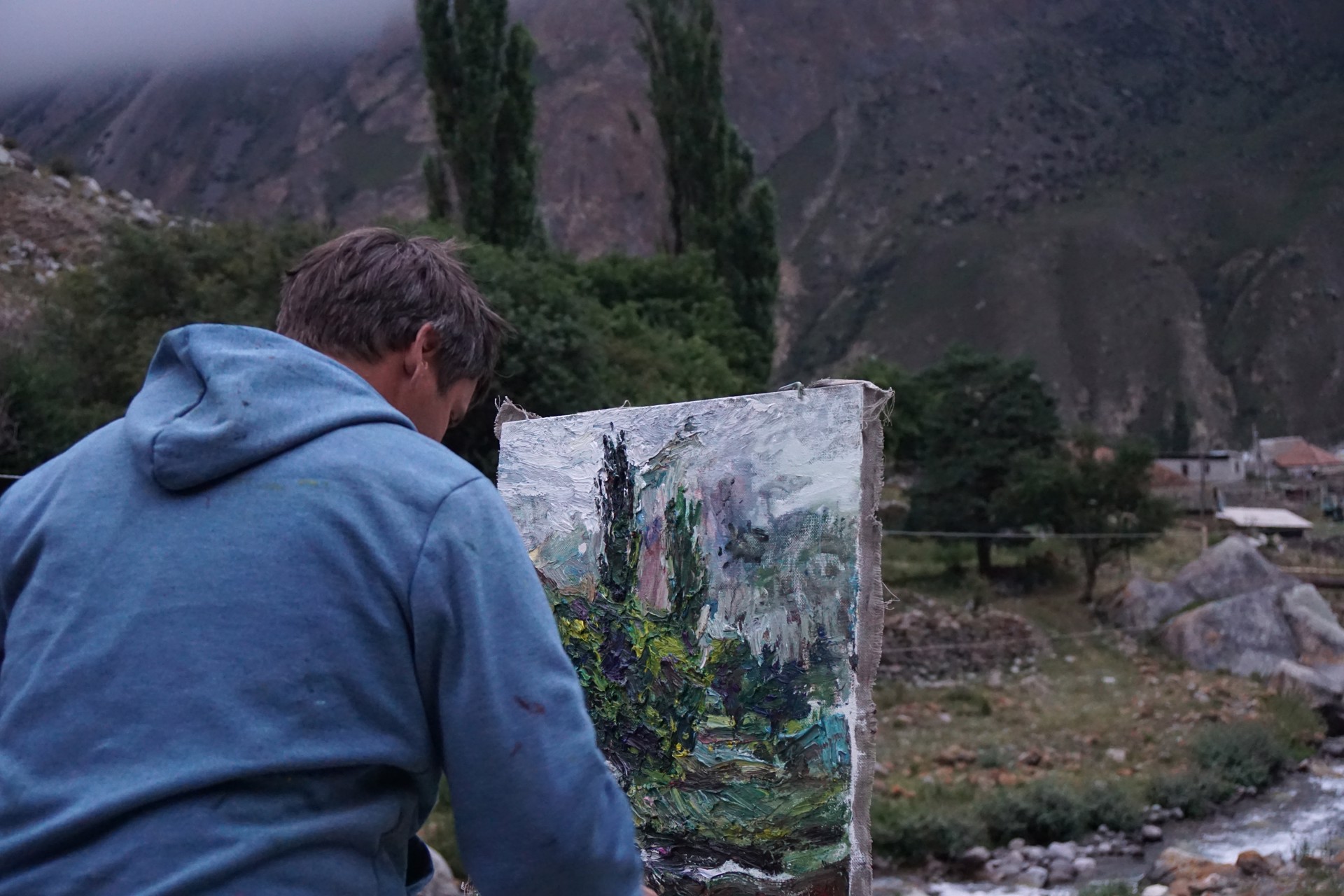A painting of a landscape with trees in the background.