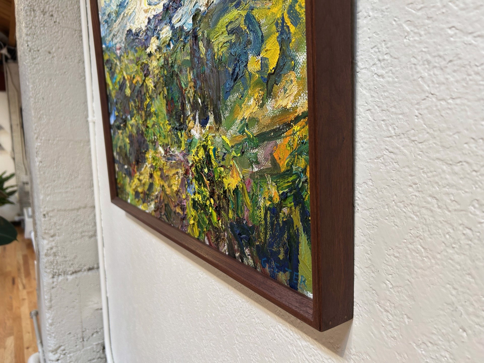 A painting of a landscape with trees and mountains in the background.