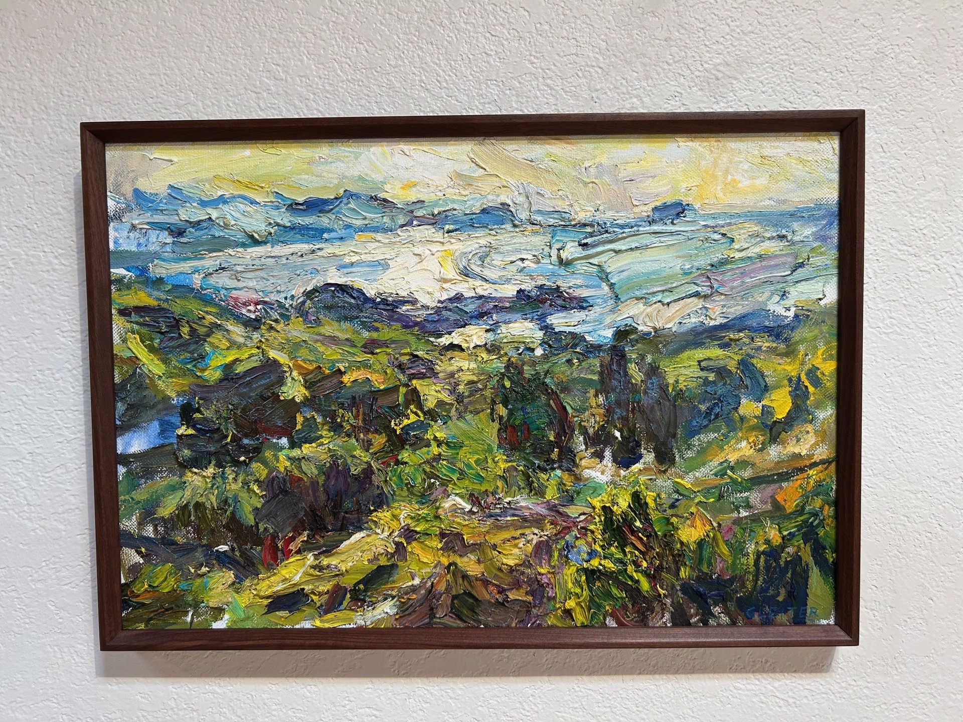 A painting of a landscape with trees and mountains in the background.