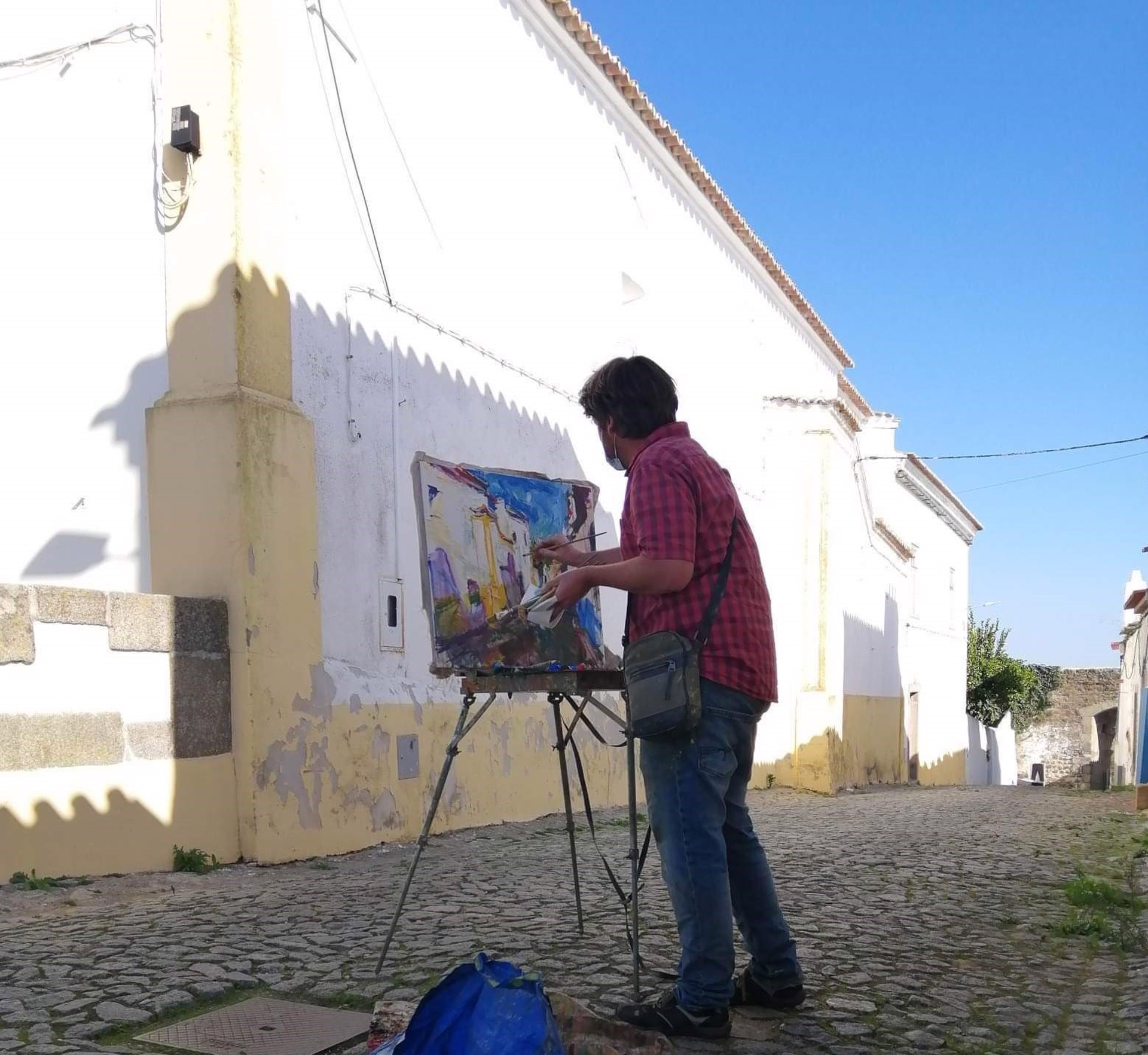 A painting of a street scene with buildings in the background.