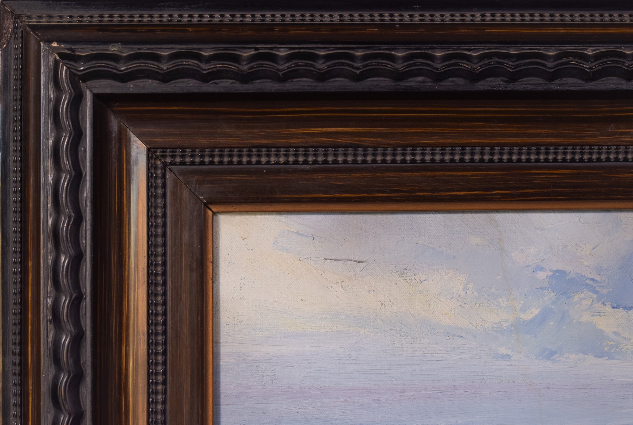 A painting of a rocky shoreline with a body of water.