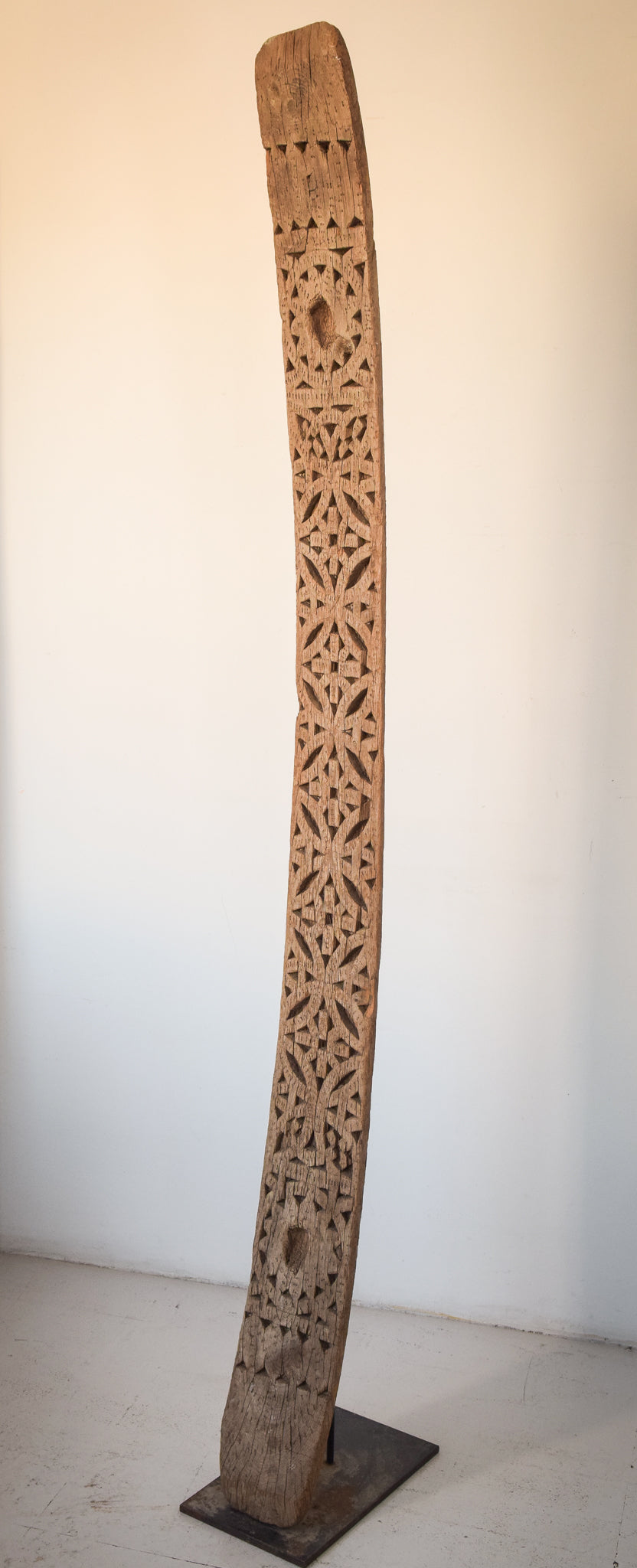 A large wooden sculpture on a metal stand.