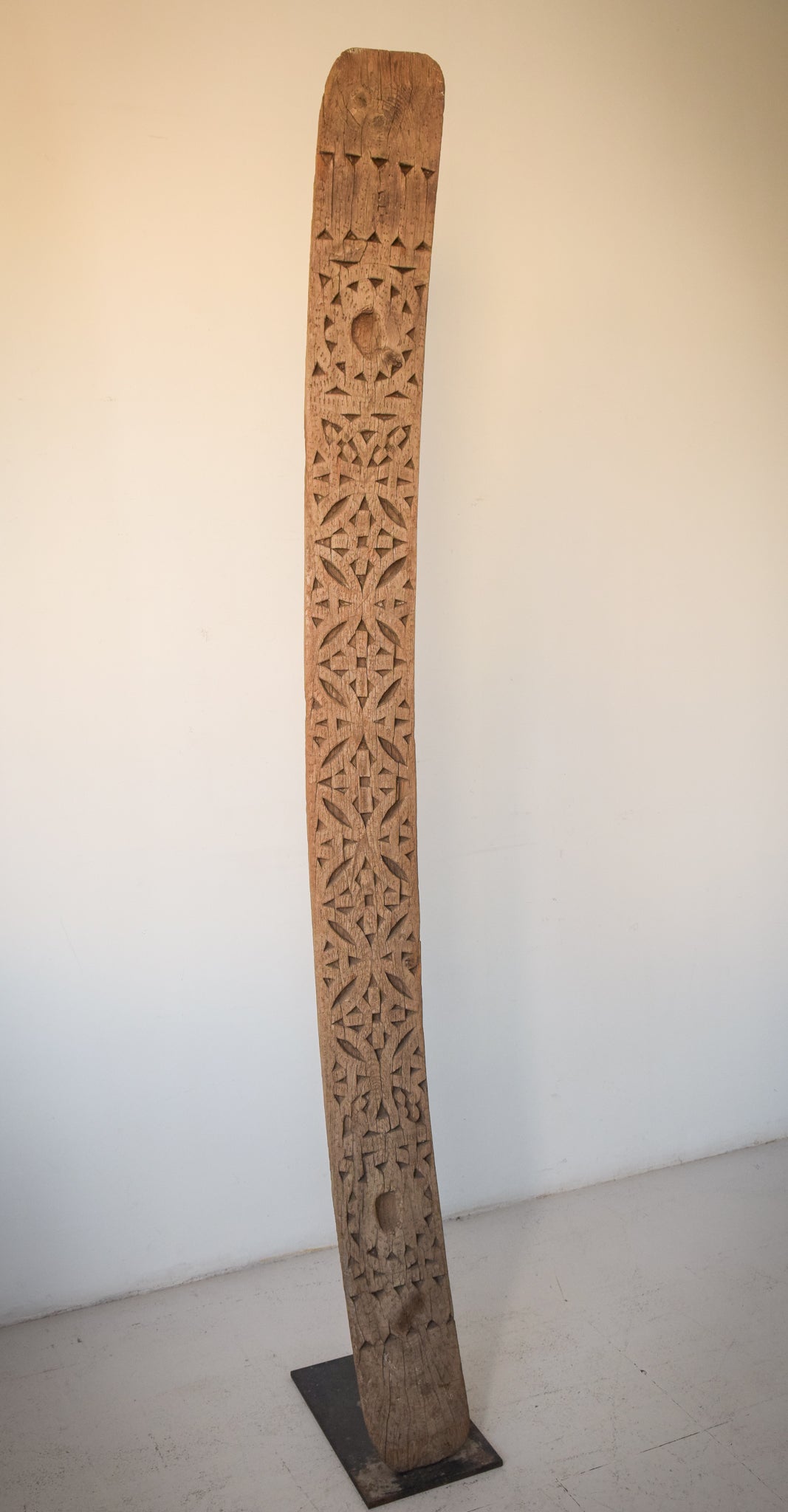A large wooden sculpture on a metal stand.