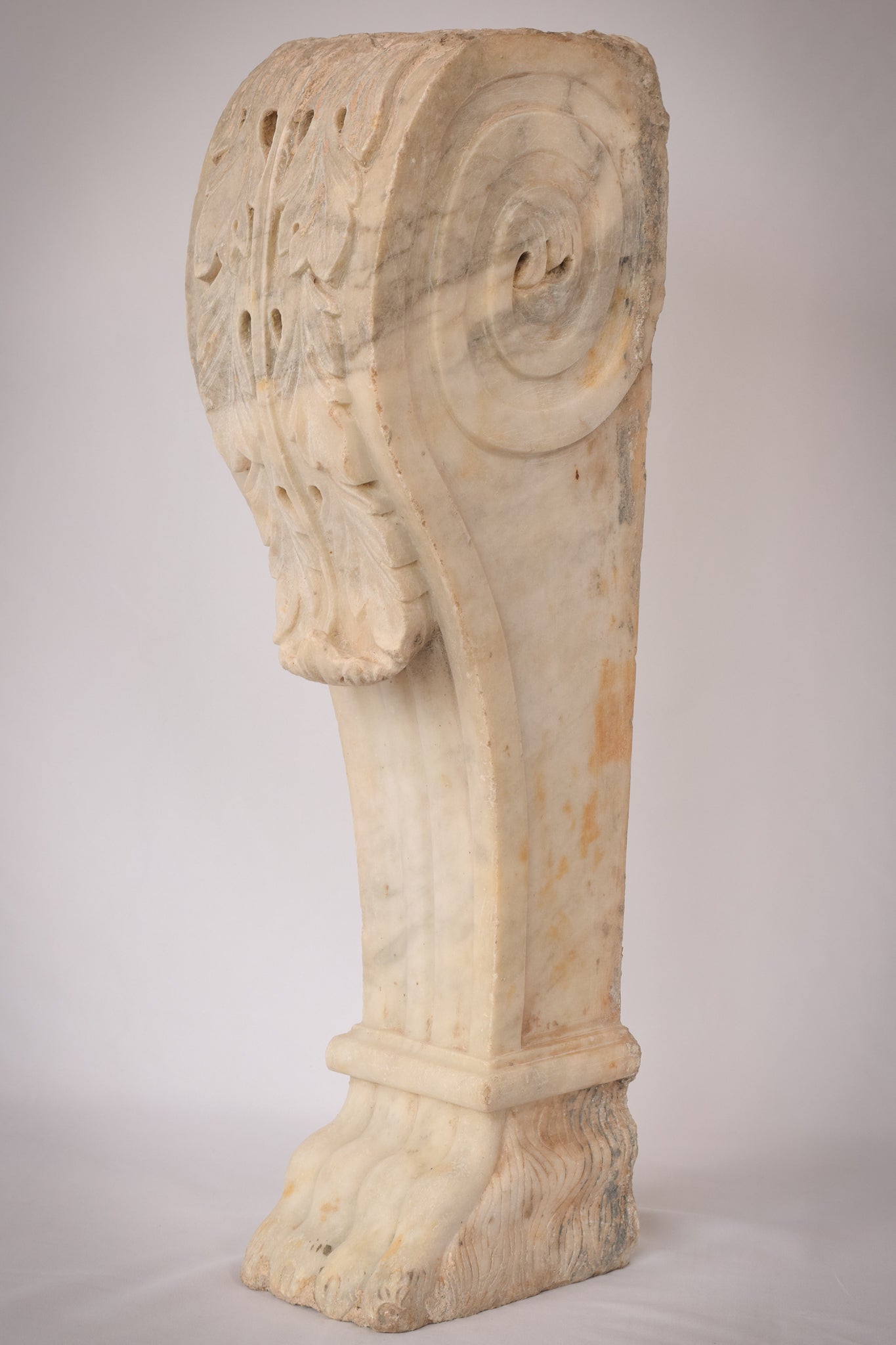 A white marble column with a leaf design on it.