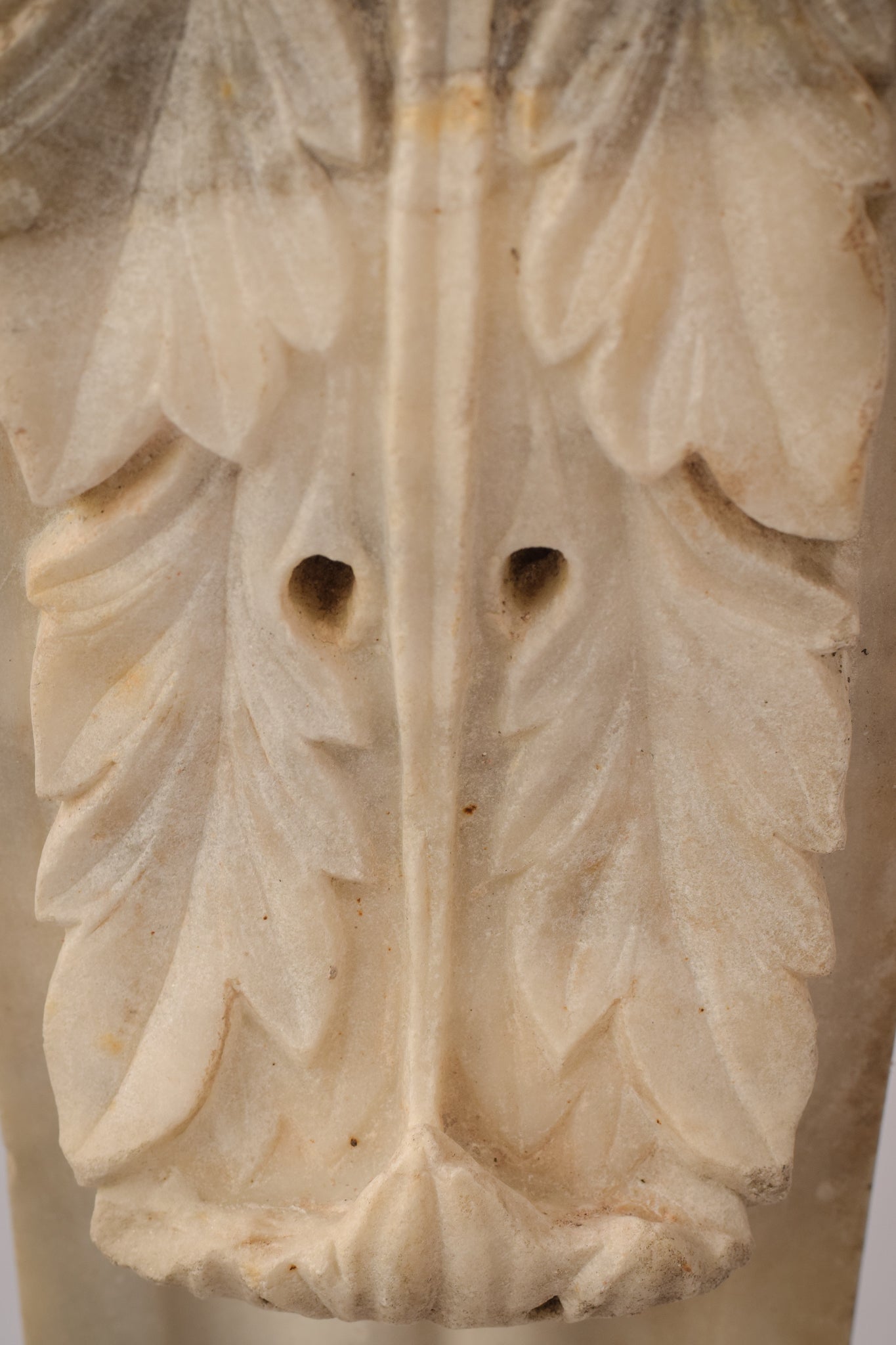 A white marble column with a leaf design on it.