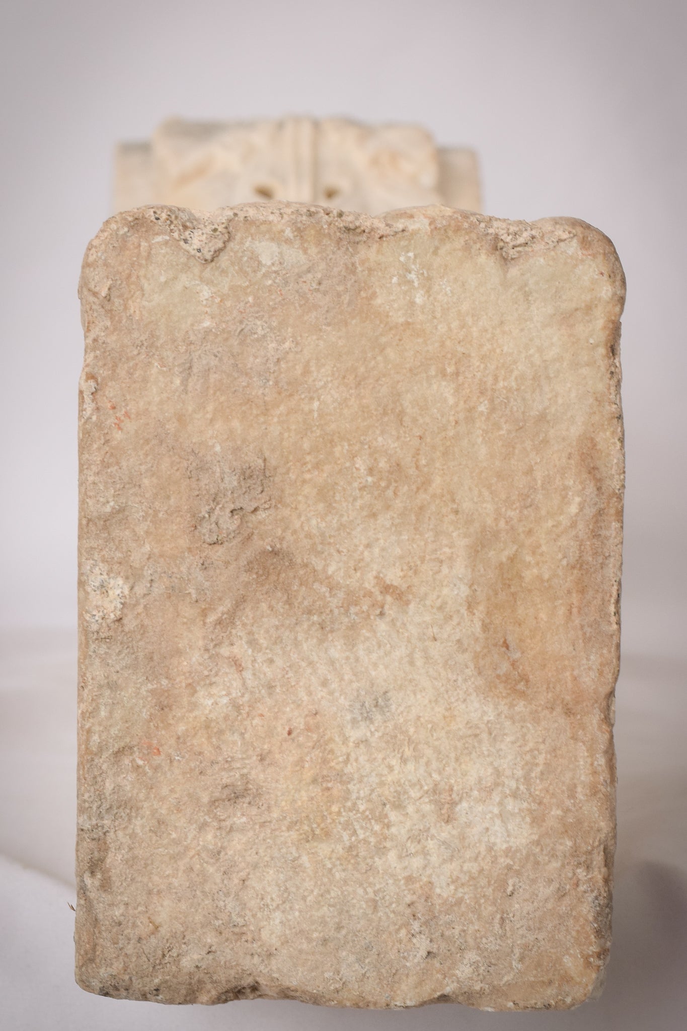 A white marble column with a leaf design on it.